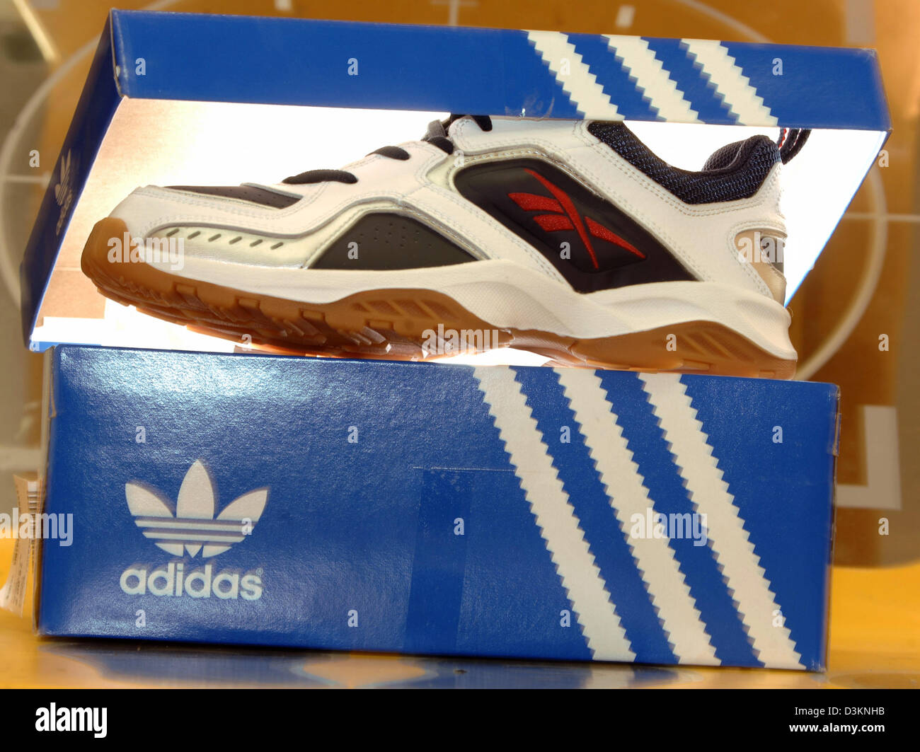 Dpa) - Bild zeigt einen Reebok Sneaker in einer Adidas-Schuh-Kiste ein Sportgeschäft in München, Deutschland, Mittwoch, 3. August 2005. Um Lücke zu weltweit führenden Sportartikel erwarb Unternehmen Nike die