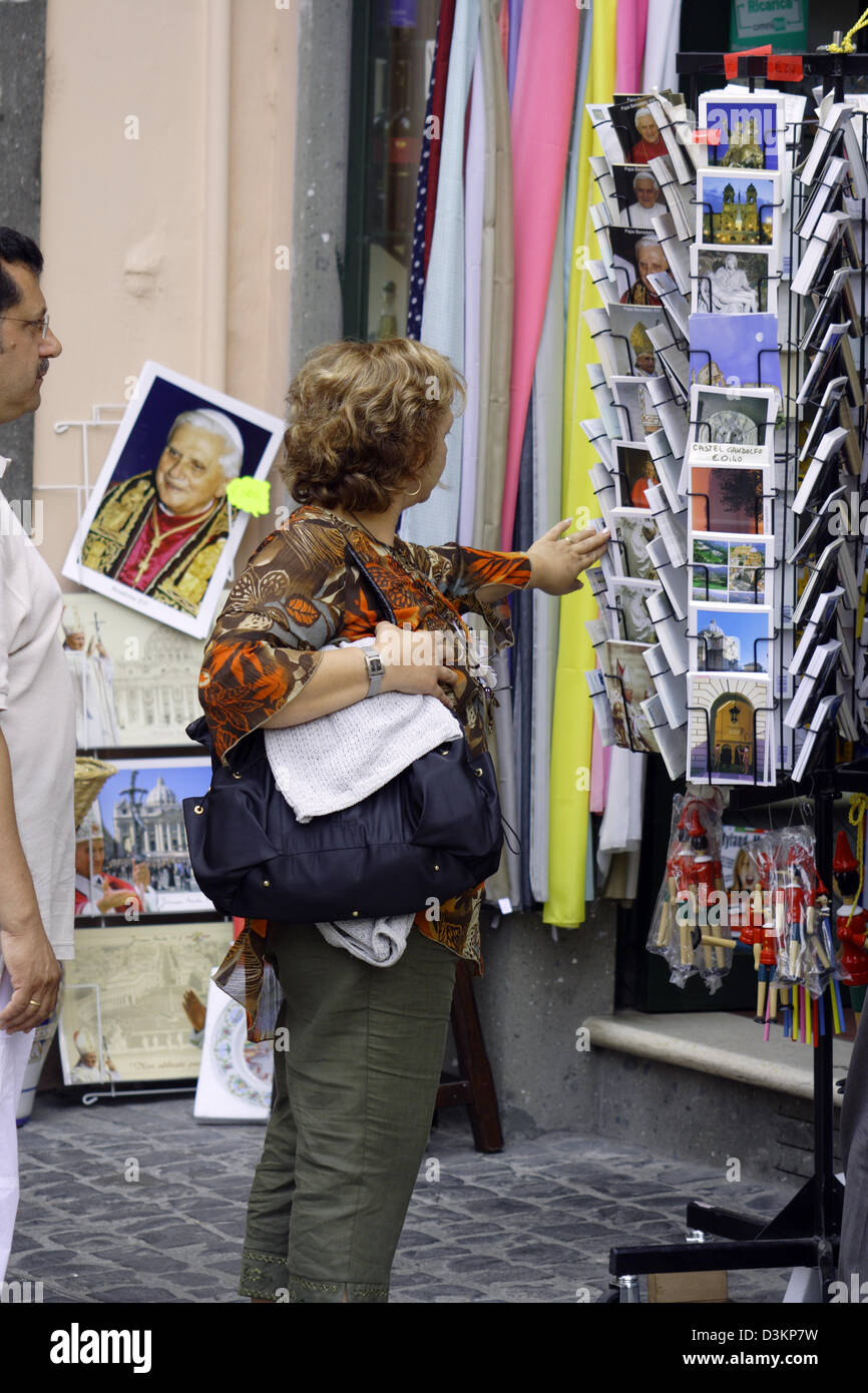 (Dpa) - eine Frau wirft einen Blick auf die Postkarten vor einen Souvenir-Shop in der Sommerresidenz des Papstes Castel Gandolfo, Italien, 7. August 2005. Im Hintergrund ist ein Bild von Papst Benedict XVI. Foto. Lars Halbauer Stockfoto