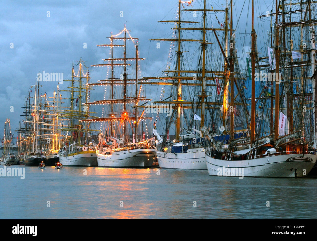 (Dpa) - im Abendlicht leuchtet die Masten der Windjammer vertäut im Hafen während des internationalen Festivals der Windjammer "Sail 2005" in Bremerhaven, Deutschland, Samstag, 13. August 2005. Die beleuchteten Schiffe sind Bestandteil einer Abend-Szenario wiederkehrend alle fünf Jahre beim internationalen Treffen der hohen Schiffe in Bremerhaven. Rund 340 Schiffe aus 20 Ländern sene Stockfoto