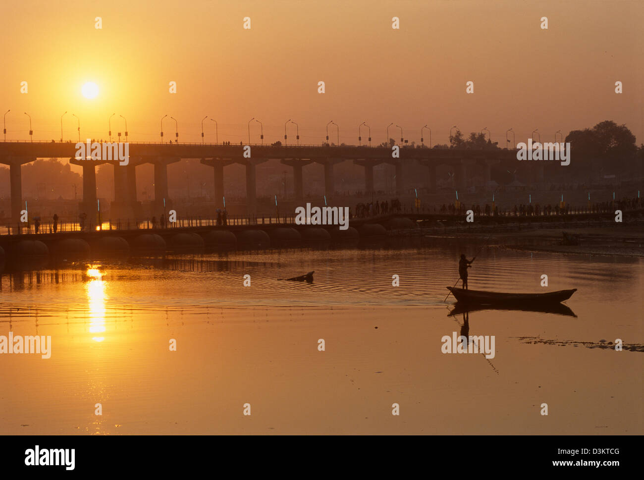 Boot wird gestakt hinter der Grand Trunk Road-Brücke bei Sonnenuntergang, Maha Kumbh Mela 2001, Allahabad, Uttar Pradesh, Indien Stockfoto