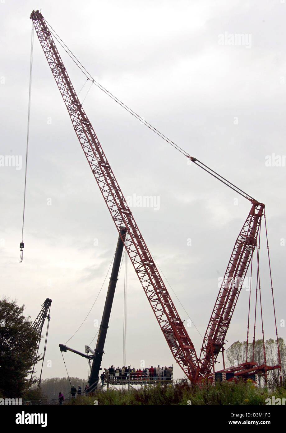 (Dpa) - zusehen Zuschauer von der Spitze einer Plattform, wie Europas größte Bergungsaufgaben Kran bei der Arbeit an den Dortmund-Ems-Kanal in der Nähe von pflegt, Deutschland, Freitag, 21. Oktober 2005 ist. Der Kran mit einer Hubkraft von 750 Tonnen wird eine 500 Tonne wiegen Kran, der kippte um und wurde zerstört, nachdem Wasser brach durch Anschluss an eine verstoßen Deich ca. eine Woche vor zu retten. Der Kanal Stockfoto