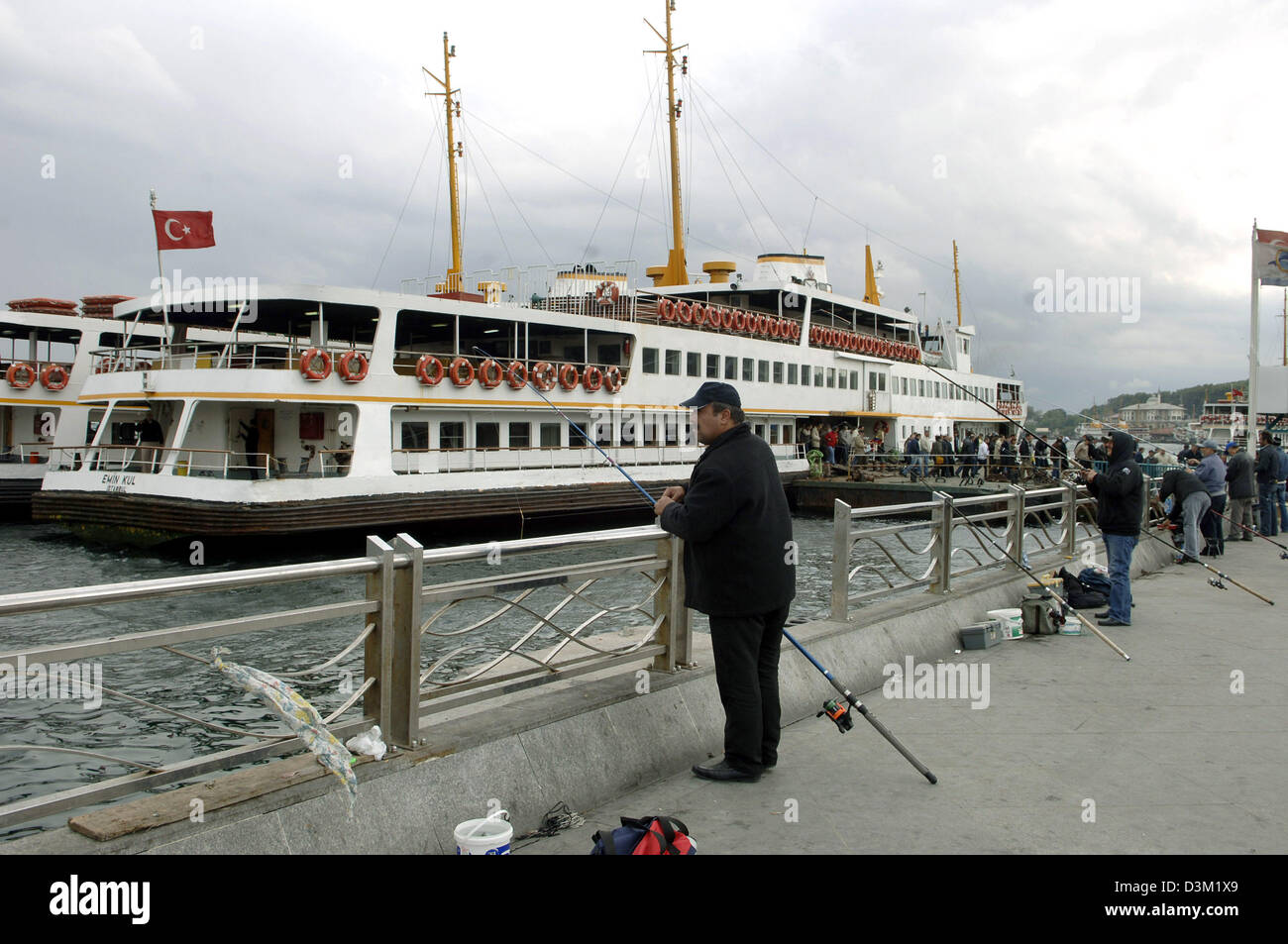 (Dpa) - Angler versuchen ihr Glück mit ihren Ruten am Goldenen Horn im Viertel Eminonu in Istanbul, Türkei, 19. Oktober 2005. Im Hintergrund ist ein Passagierschiff. Foto: Achim Scheidemann Stockfoto