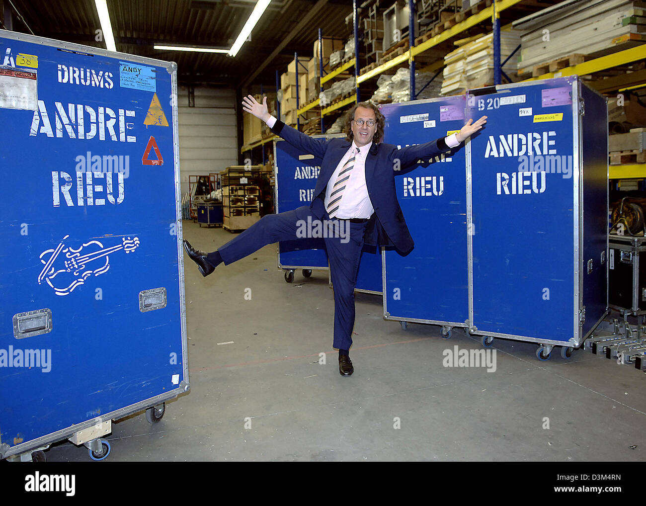 (Dpa) - Sterne niederländische Geigerin, die Andre Rieu scherzhaft zwischen großen Behältern, die mit seinem Namen in seinem Lager in Maastricht, Niederlande, 2. November 2005 darstellt. Der 56 Jahre alte Musiker ist kurz vor dem start des ersten Teil seiner Tour durch Kanada und die USA, wo er in 13 Großstädten durchführen wird. Die komplette Ausrüstung seiner Crew, die 40 Personen zu zahlen, war schon loade Stockfoto