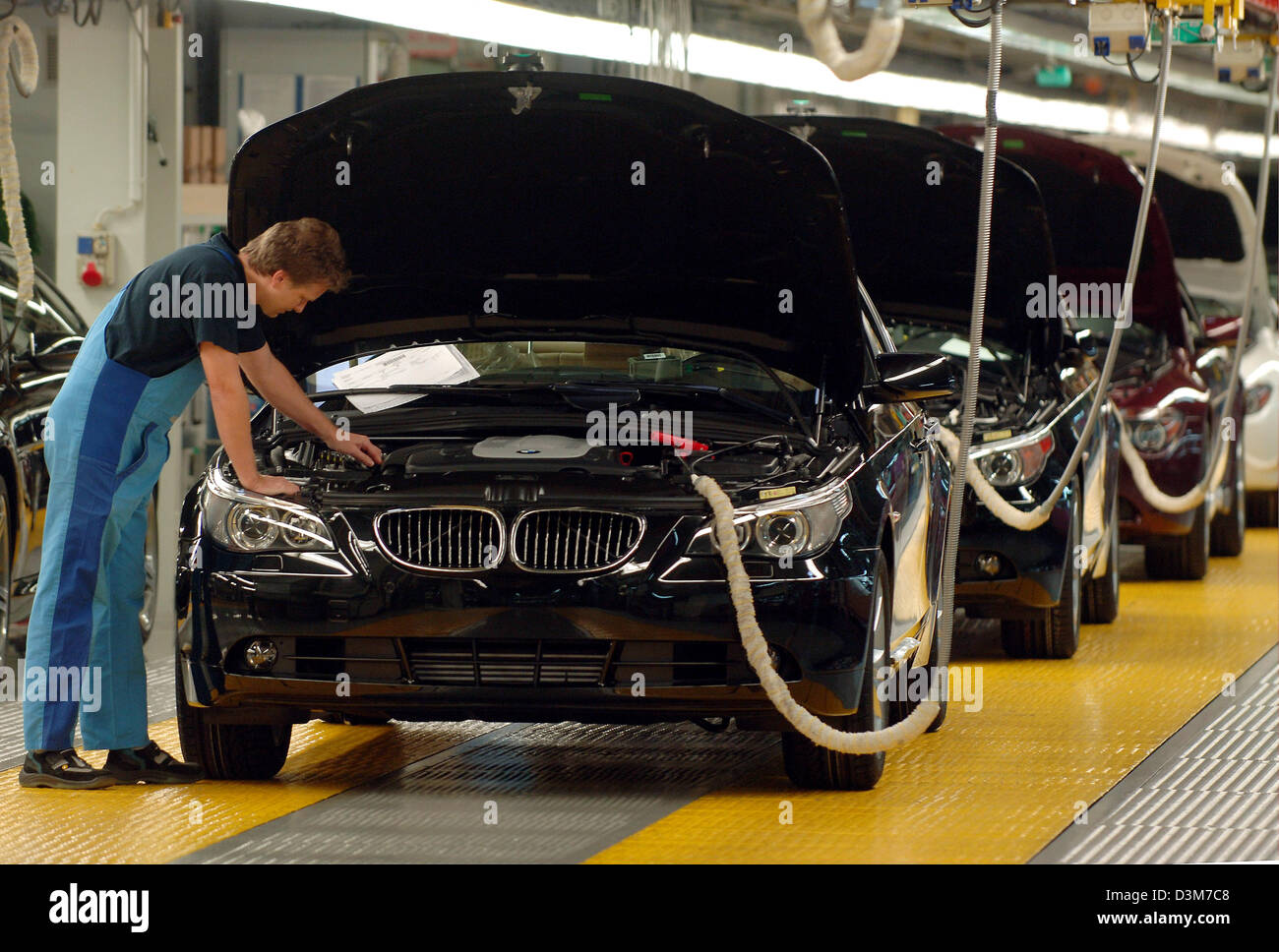 (Dpa) - das Bild zeigt einen BMW-Mitarbeiter bei der Endkontrolle von einem schwarzen BMW 5er Auto am Produktionsstandort des Unternehmens in Dingolfing, Deutschland, Dienstag, 13. Dezember 2005. Foto: Armin Weigel Stockfoto