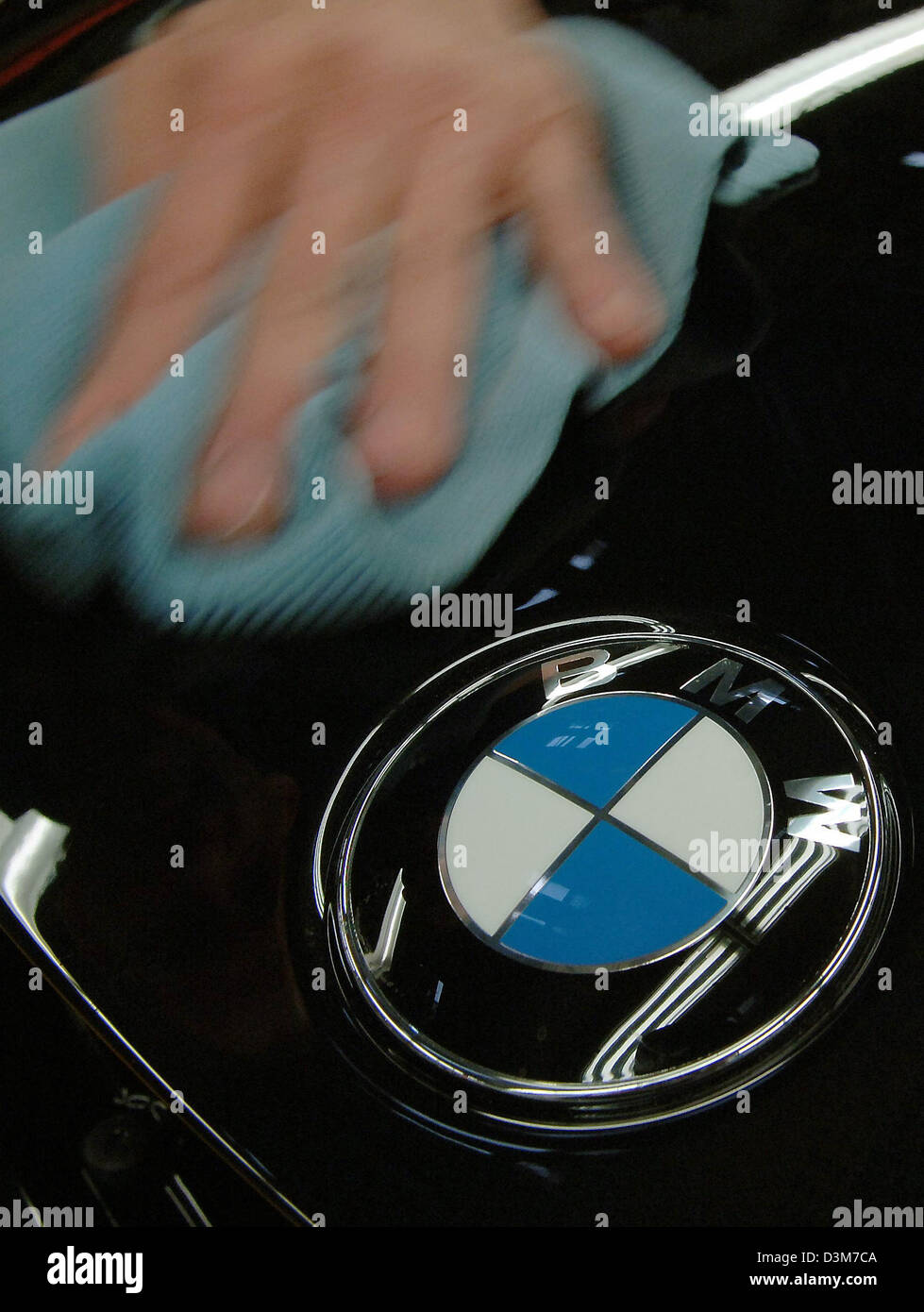 (Dpa) - das Bild zeigt eine Hand, die Reinigung der Motorhaube eines schwarzen BMW 6er-Reihe Autos am Produktionsstandort des Unternehmens in Dingolfing, Deutschland, Dienstag, 13. Dezember 2005. Foto: Armin Weigel Stockfoto