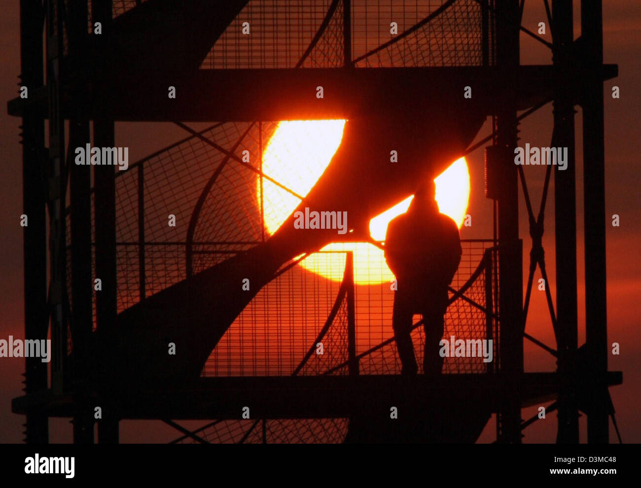 Ein Mann geht die Treppe hinauf zum Aussichtsturm am Hafen von Friedrichshafen während des Sonnenuntergangs, Deutschland, Dienstag, 24. Januar 2006. Foto: Patrick Seeger Stockfoto