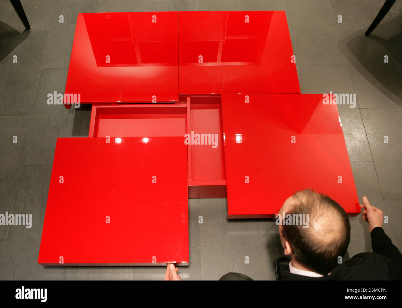 Alfred Roos, Geschäftsführer von Conde House Europe GmbH, ein japanischer  Hersteller von Möbeln, präsentiert einen rot gefärbten Hochglanz Couchtisch  im Ausstellungsraum eine Niederlassung in Köln, Deutschland, Donnerstag,  26. Januar 2006. Der Marktführer