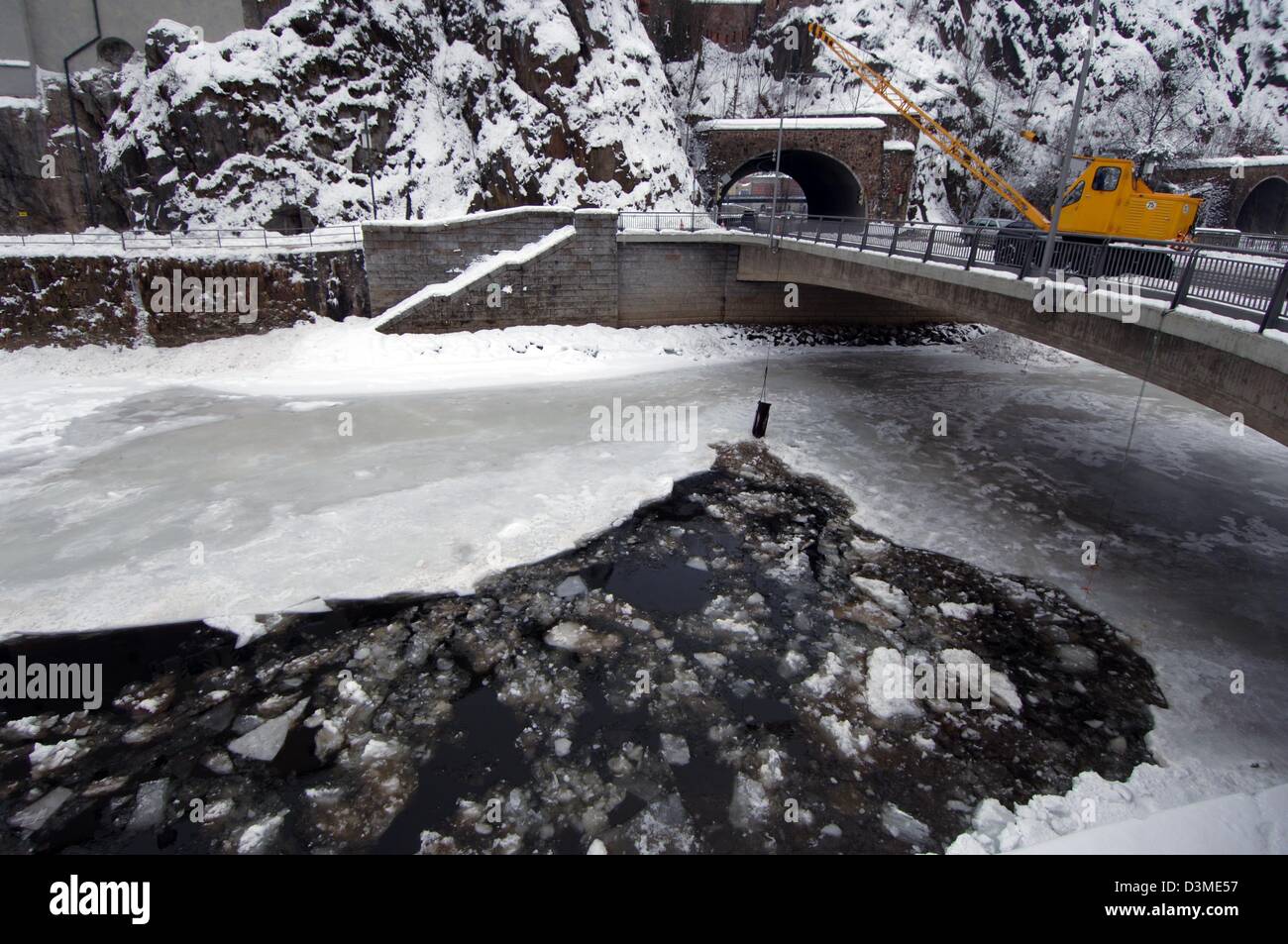 Ein Kran auf einer Brücke crusht eine Schicht von 20 Zentimeter dickes Eis auf dem Fluss Ilz mit einem Gewicht an seinen Arm in Passau, Deutschland, Dienstag, 14. Februar 2006. Die Eismassen werden schwimmen hinunter den Fluß Danub erwartet, zur Vermeidung von Hochwasser durch eine Barriere aus Eis, ein Sprecher von Passau angegeben. Mehrere Pfarreien in Bayern haben die Vorbereitungen für eine mögliche Flut initiiert. Stockfoto