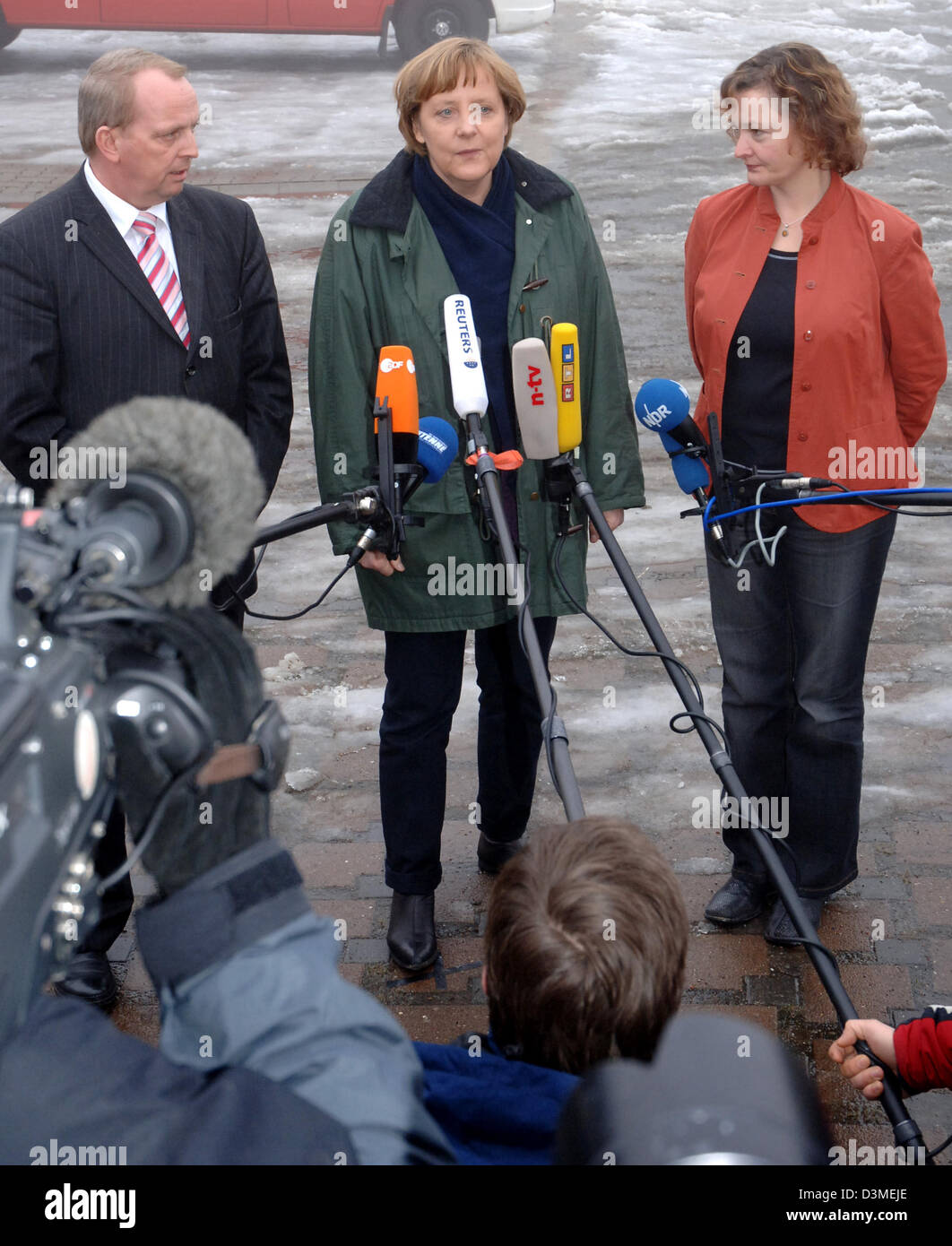 Bundeskanzlerin Angela Merkel (C, CDU) im Gespräch mit Journalisten nach ihrem Besuch in der Krise Management Group in Bergen, Deutschland, Sonntag, 19. Februar 2006. Neben ihrem Till Backhaus Minister für Landwirtschaft des Bundeslandes Mecklenburg-Vorpommern (L, SPD) und Kerstin Kasser, District Administrator Rügen (R, linke Party.PDS), abgebildet. (Zu Lmv 4369 Vom 19.02.2006) Phot Stockfoto