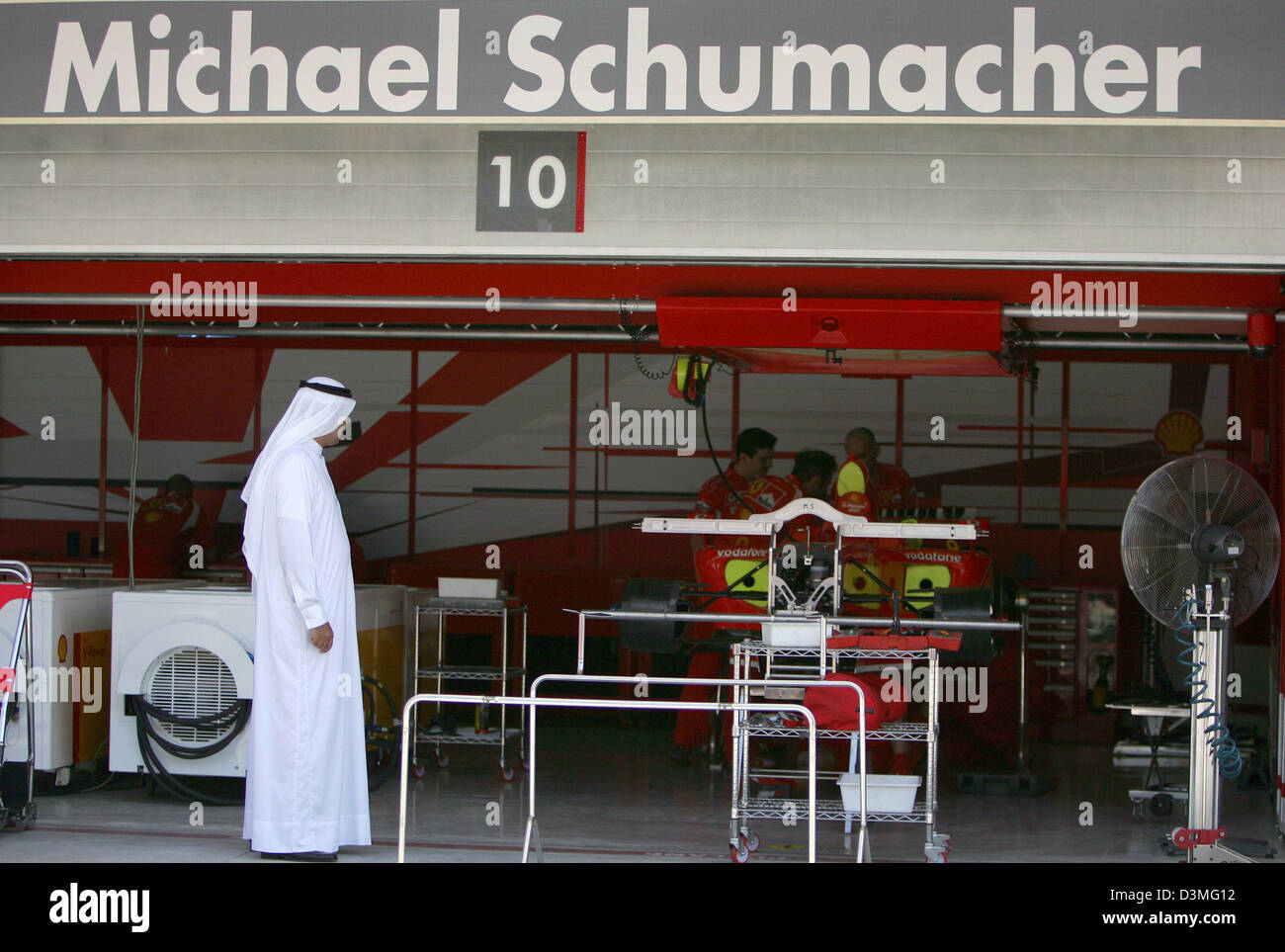 Ein Scheich wirft einen Blick in die Ferrari-Grube am deutschen Formel1 Fahrer Michael Schumacher Rennwagen in der Formel1 Rennstrecke in der Nähe von Manama, Bahrain, Mittwoch, 8. März 2006. Das erste Rennen der F1-Weltmeisterschaft 2006, der Grand Prix von Bahrain, wird hier auf Sonntag, 12. März 2006 stattfinden. Foto: Carmen Jaspersen Stockfoto