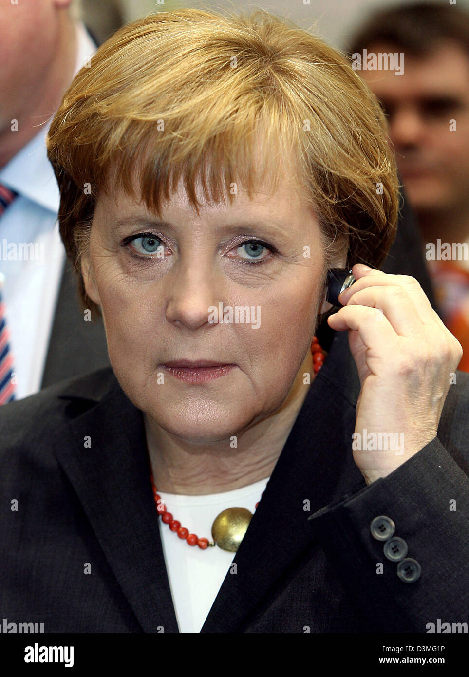 Bundeskanzlerin Angela Merkel testet Motorola Bluetooth-Kopfhörer auf der führenden Messe für Datenverarbeitung und Kommunikationstechnik "CeBIT 2006" in Hannover, Deutschland, Donnerstag, 9. März 2006. Rund 6.300 Unternehmen aus 70 Ländern werden ihre Neuheiten von 09 März, 15. März 2006 präsentieren. Foto: Kay Nietfeld Stockfoto