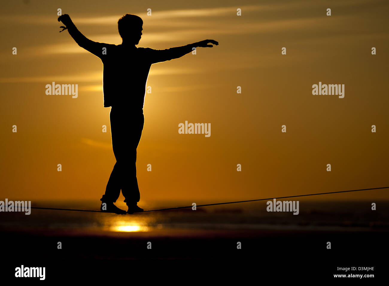 Slackline Walking on line Silhouette bei Sonnenuntergang Stockfoto