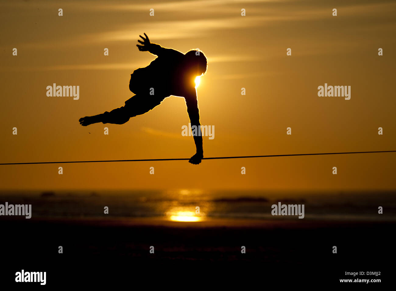 Slackline Trick Silhouette bei Sonnenuntergang Stockfoto