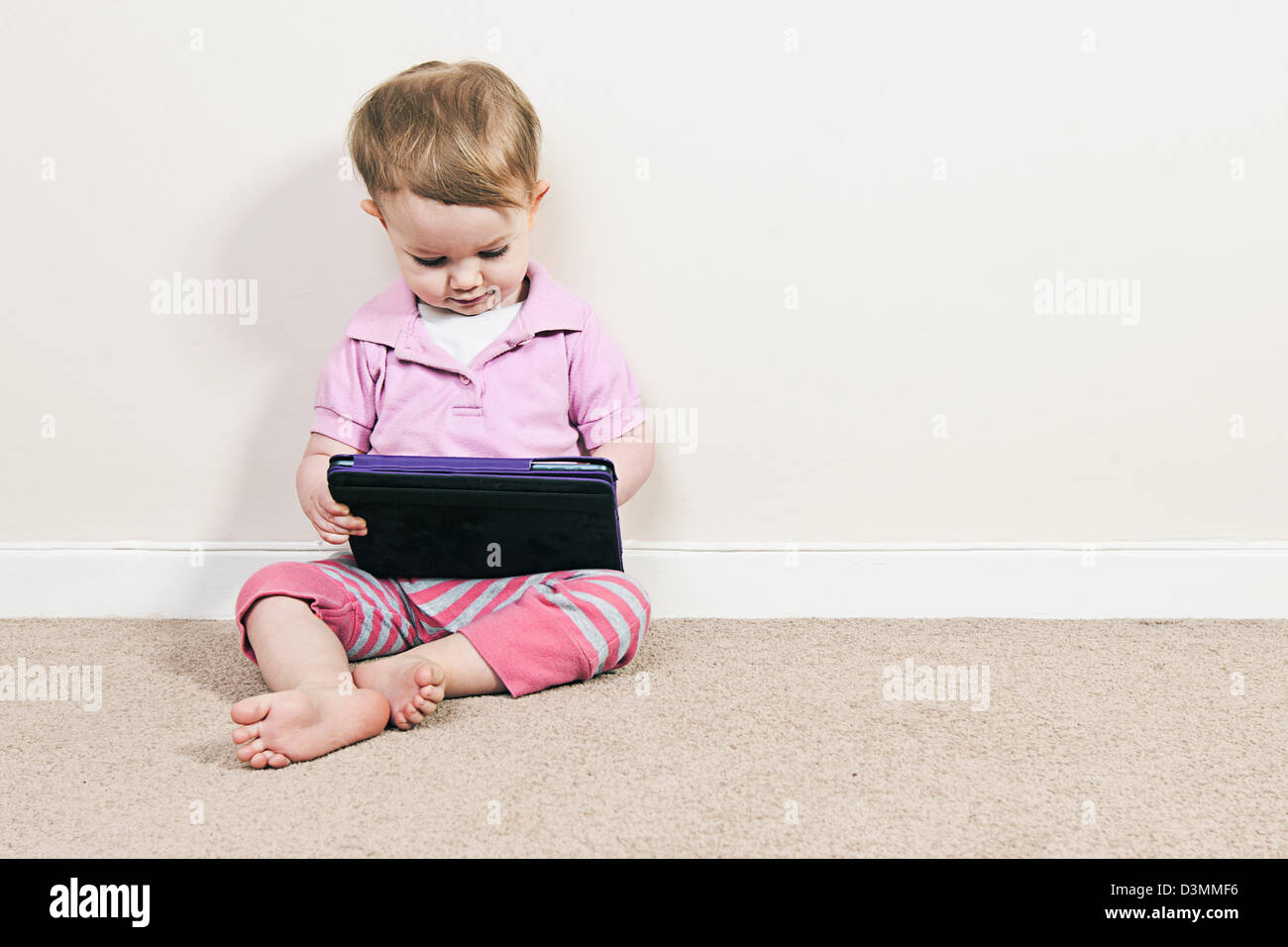 Babymädchen auf dem iPad Mini Stockfoto