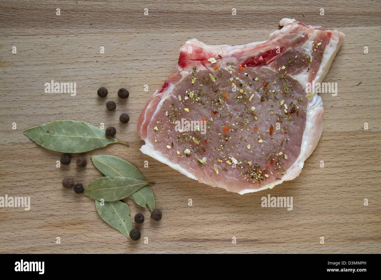 rohes Schweinefleisch Chop auf ein Schneidebrett mit Gewürzen Stockfoto