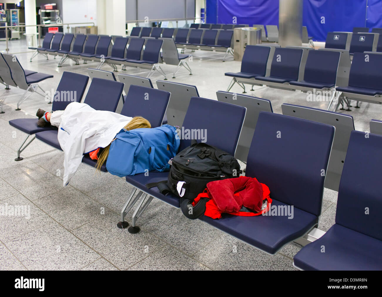 Passagier schläft auf sitzen in einem leeren Nacht Flughafen nach Annullierung des Fluges Stockfoto