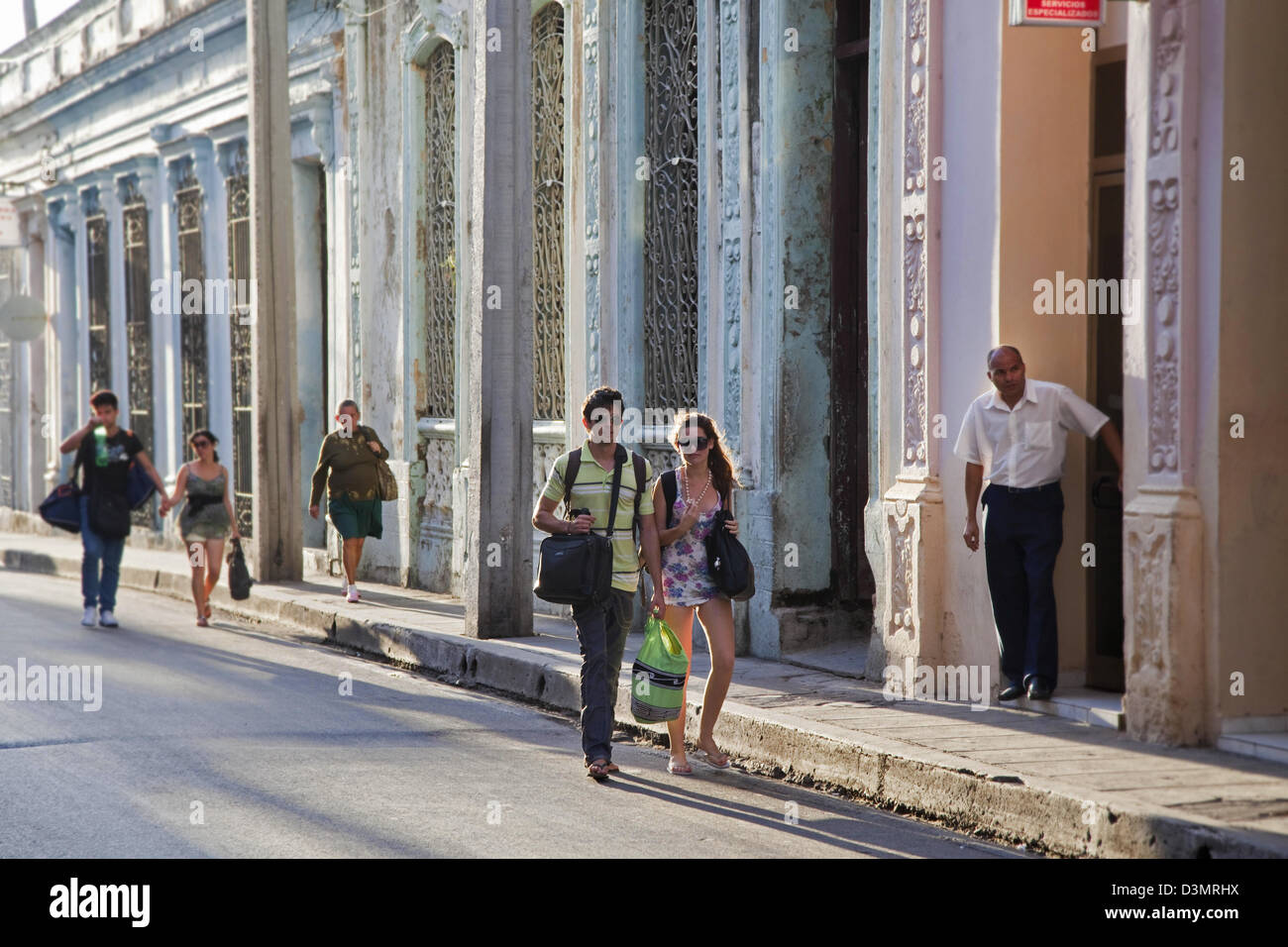 Touristen, die Wanderschaft entlang Kolonialhäusern in Santa Clara, Villa Clara, Kuba, Karibik Stockfoto
