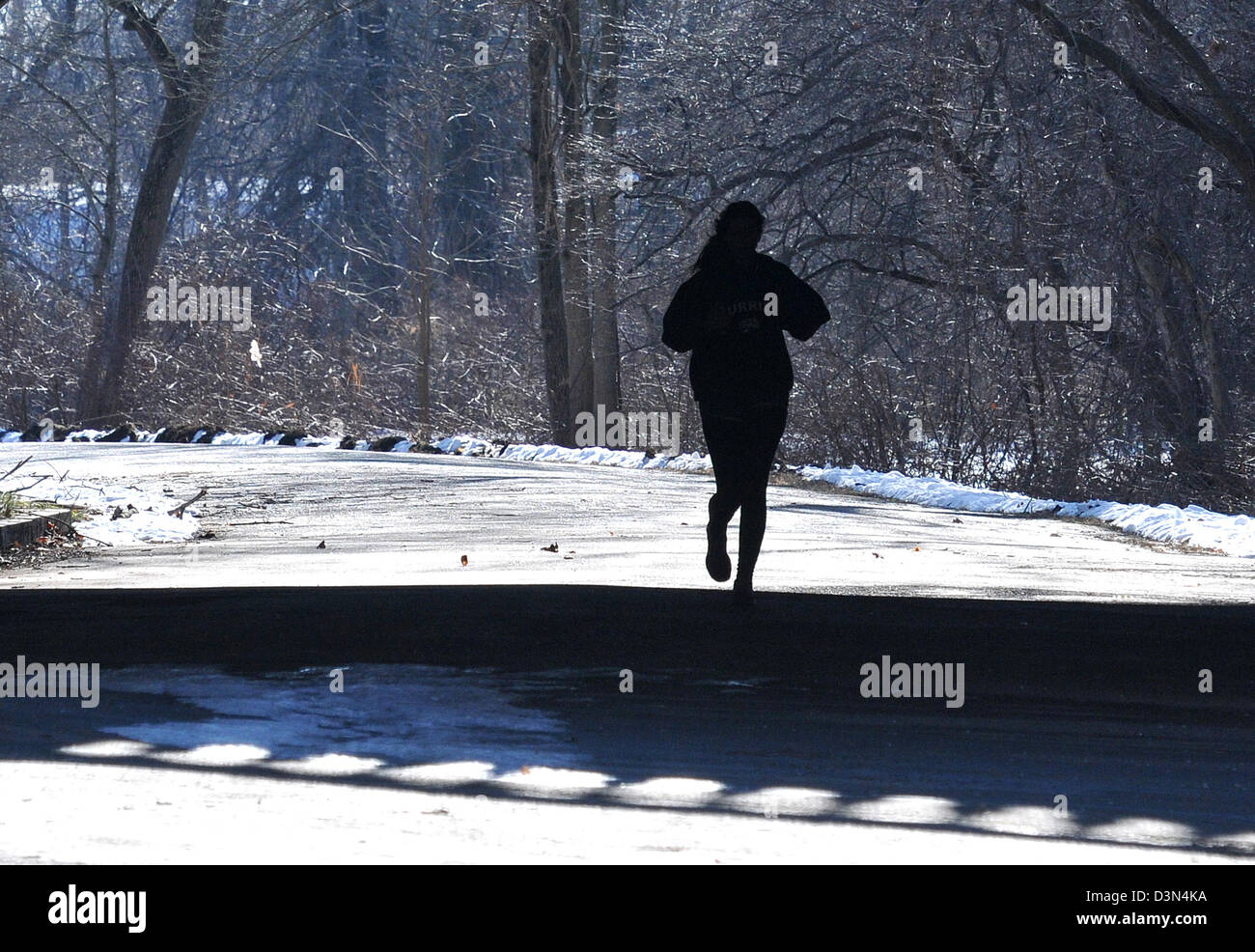 Frau läuft durch einen Park in New Haven CT unter einer Brücke im winter Stockfoto