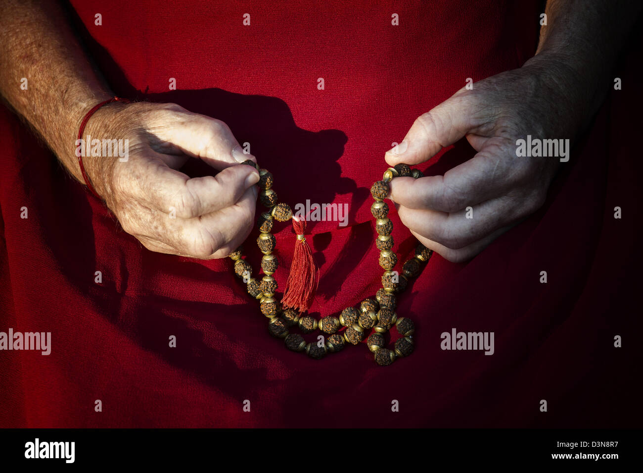 Old mans Händen mit indischen Rudraksha / Japa Mala Gebetskette Stockfoto