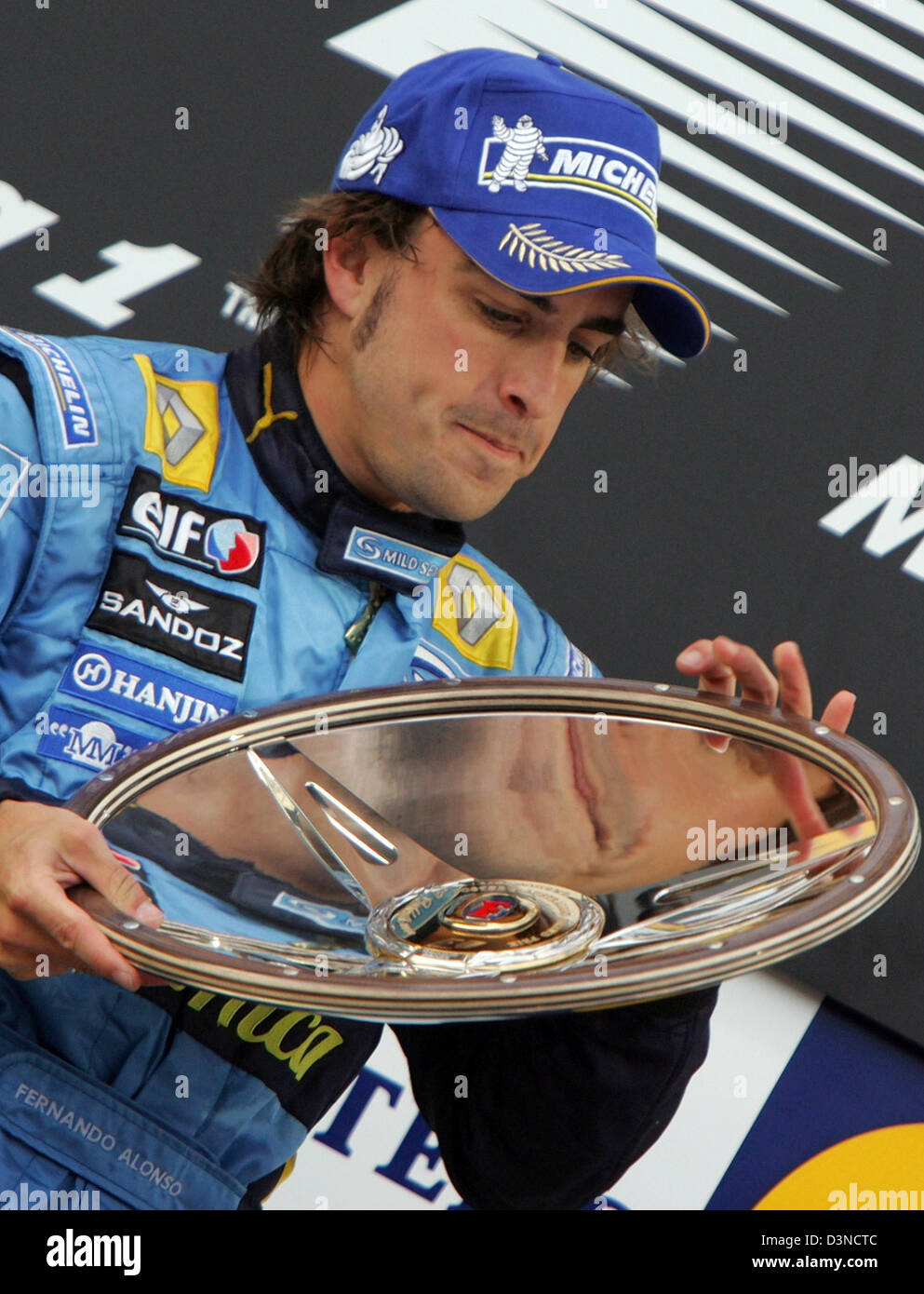 Spanische Formel1-Fahrer Fernando Alonso von Renault F1 racing Team auf dem Podium die Trophäe in den Händen hält, nach dem Gewinn der Australian Formula One Grand Prix auf dem Stadtkurs Albert Park in Melbourne, Australien, Sonntag, 2. April 2006 feiert. Schumacher schied aus dem Rennen. Foto: Rainer Jensen Stockfoto