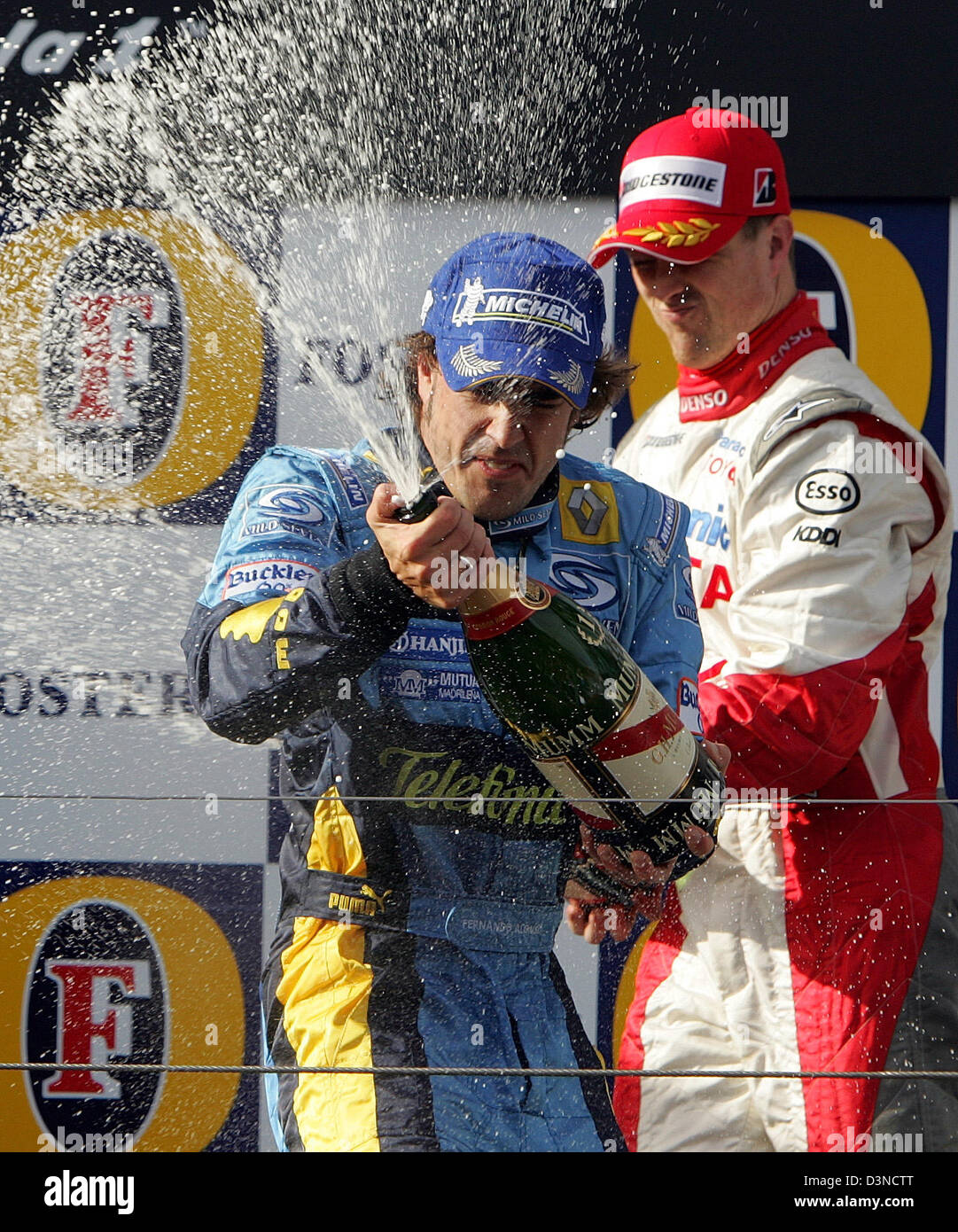 Spanische Formel1-Fahrer Fernando Alonso von Renault F1 Racing Team (vorne) und deutschen Ralf Schumacher (wieder) Toyota Racing Spray Champagner auf dem Podium nach dem Gewinn der Australian Formula One Grand Prix auf dem Stadtkurs Albert Park in Melbourne, Australien, Sonntag, 2. April 2006. Foto: Rainer Jensen Stockfoto