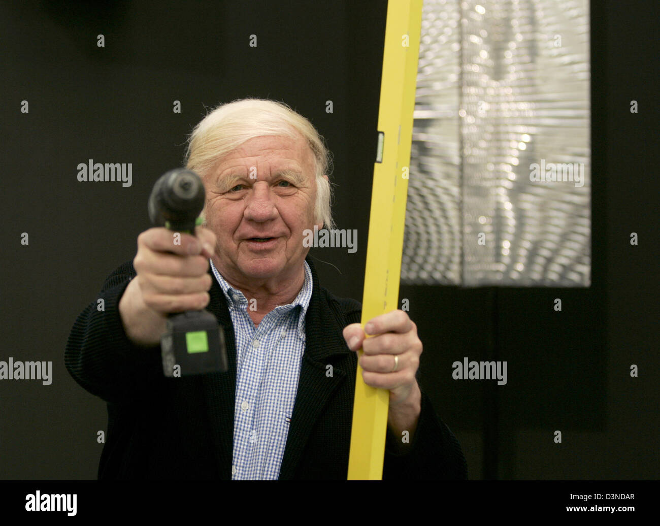 Deutsche Avantgarde-Künstler Heinz Mack lächelt, als er einen Akkuschrauber und einen Wasserstand in seinen Händen in der Kunstgalerie "Kunstpalast" in Düsseldorf, Donnerstag, 6. April 2006 hält. Die Ausstellung "ZERO-Restrospektive" zeigt Kunstwerke, Installationen, Skulpturen und Gemälde der internationalen Avantgarde-Kunstbewegung aus den 1950er und 1960er Jahren. Foto: Roland Weihrauc Stockfoto