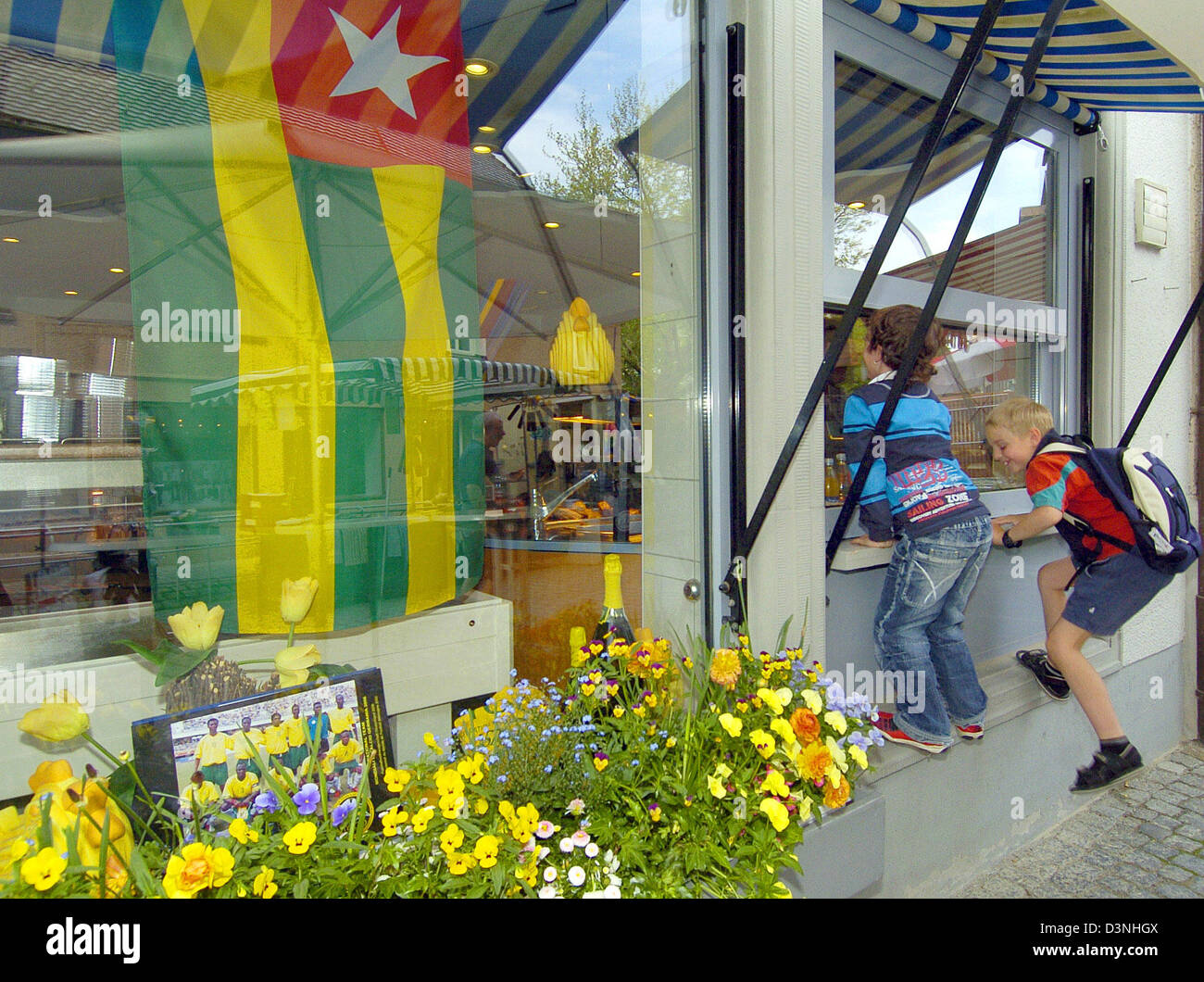 Eine togolesische Flagge und ein Gruppenbild hängt im Schaufenster eines Geschäfts in Wangen, Deutschland, 15. Mai 2006. Die Stadt Wangen geht über die Ankunft der Togos Fußball-Nationalmannschaft. Die westafrikanischen Team wird während der FIFA WM 2006 in Wangen lodge. Foto: Stefan Puchner Stockfoto