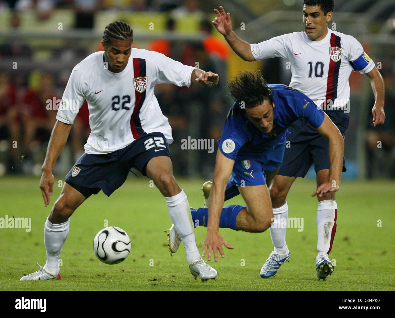 Italiens Andrea Pirlo (C) Oguchi Oneywu (L) und Claudio Reyna (R) der Vereinigten Staaten während des Spiels der Gruppe E der FIFA-WM 2006 zwischen Italien und den USA in Kaiserslautern, Deutschland, Samstag, 17. Juni 2006 in Angriff genommen wird. DPA/RONALD WITTEK +++ Mobile Dienste, +++ entnehmen Sie bitte auch die allgemeinen Geschäftsbedingungen der FIFA. Stockfoto