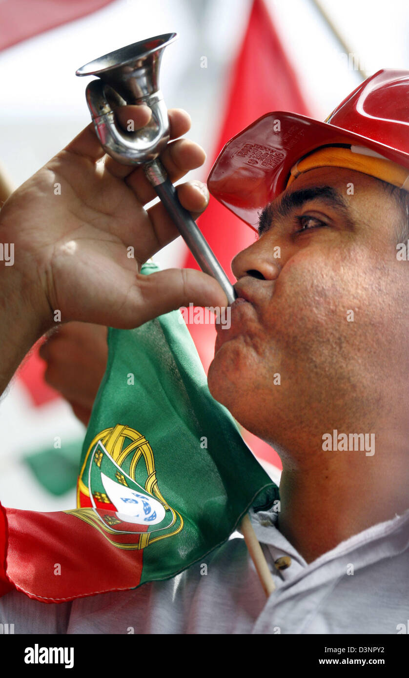 Ein Mitarbeiter der Adam Opel AG bläst sein Horn mit der portugiesischen Flagge in Rüsselsheim, Deutschland, Dienstag, 20. Juni 2006. Auf einer Solidaritätskundgebung rund 5.000 Opel Mitarbeiter fordern Sie die Opel-Mutter General Motors (GM) Werk Azambuja, Portugal mit 1.150 Mitarbeiter zu halten. Klaus Franz, Leiter der Opel-Betriebsrat, ist skeptisch über die europäischen GM-Strategie bis 2014 zu gefährden Stockfoto