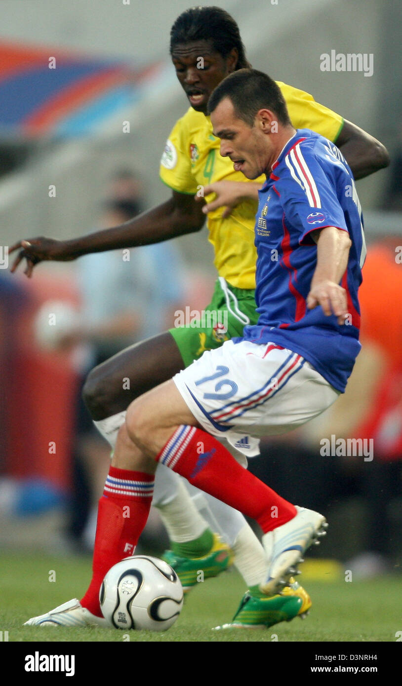 Emmanuel Adebayor (L) aus Togo und Willy Sagnol (R) aus Frankreich kämpfen um den Ball während des Spiels der Gruppe G der FIFA WM 2006 zwischen Togo und Frankreich in Köln, Deutschland, Freitag, 23. Juni 2006. DPA/ROLAND WEIHRAUCH +++ Mobile Dienste, +++ entnehmen Sie bitte den allgemeinen Geschäftsbedingungen der FIFA. Stockfoto