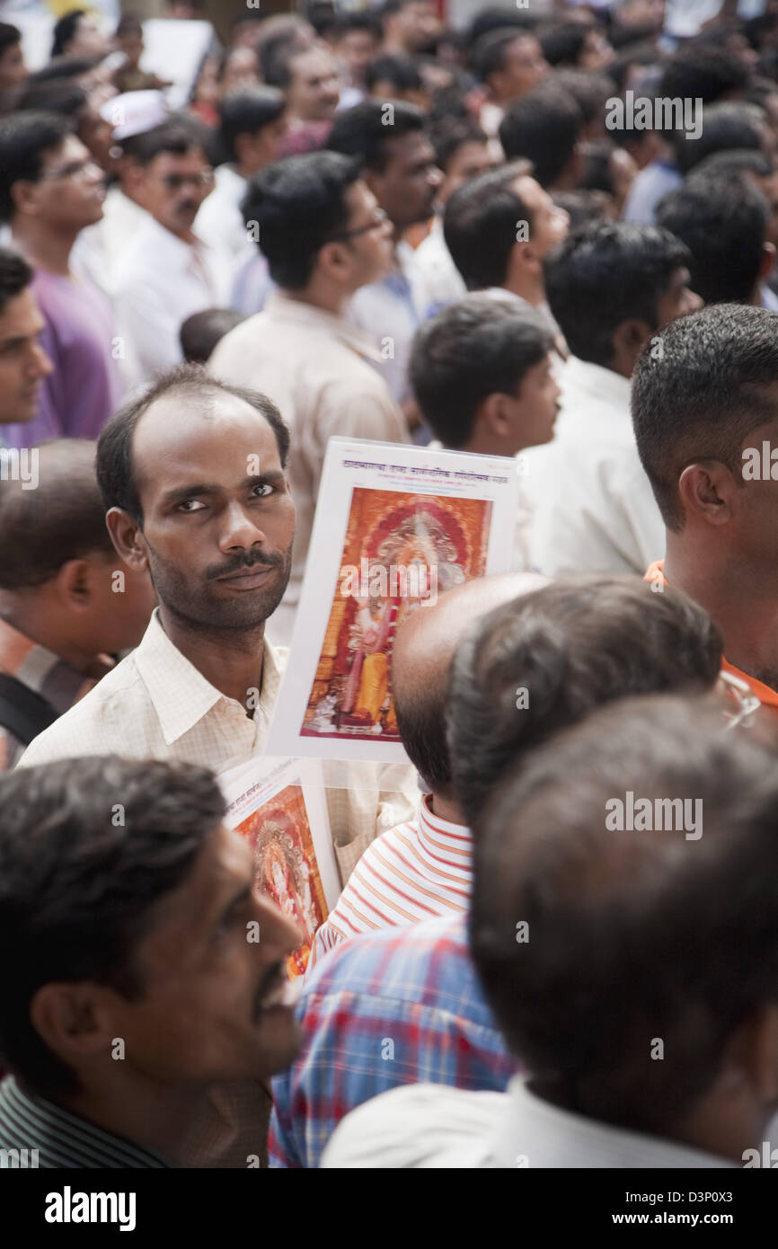 Hawker, Verkauf von Postern von Lord Ganesha an eine religiöse Prozession, Mumbai, Maharashtra, Indien Stockfoto