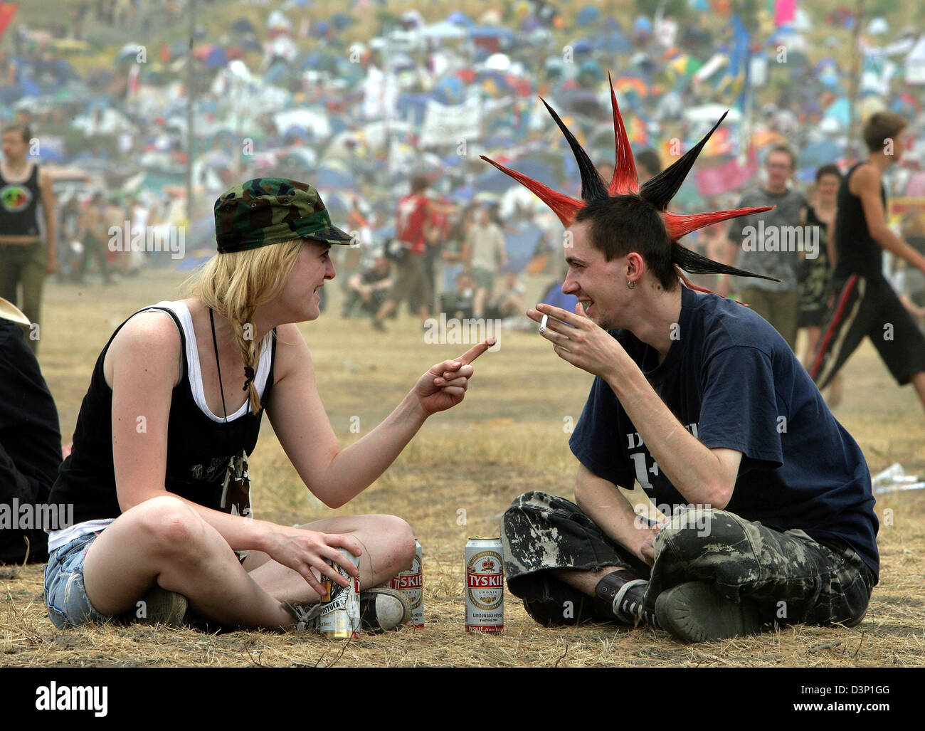 Zwei Besucher chat bei der 'Przystanek Woodstock' open Air-Festival in der Nähe von Kostrzyn, Polen, Freitag, 28. Juli 2006. Die Stadt 80 Kilometer östlich von Berlin, Deutschland beherbergt das größte Musikfestival Europas am 28. und 29 Juli. Bei freiem Eintritt werden 350.000 Besucher zum Festival unter dem Motto erwartet ", Freundschaft, Musik lieben". Mehr als 30 Rock und folk-Bands aus Polen, Deutschland, Ukr Stockfoto