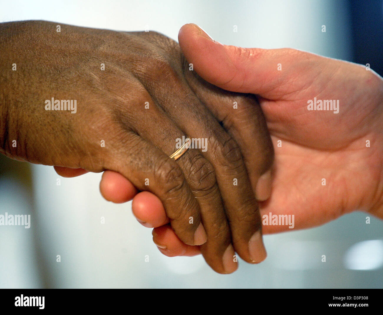 Das symbolische Bild zeigt die Hände von einem sudanesischen (L) und ein deutscher in Tübingen, Samstag, 12. August 2006. Immer mehr deutsche Leben mit ausländischen Partnern. Das statistische Bundesamt gab bekannt, dass gab es 1,3 Millionen binationalen Paaren in Deutschland im Jahr 2005. Die Zahl hat sich seit 1996 verdoppelt und macht mehr als 6 Prozent aller Paare. Foto: Oliver Berg Stockfoto