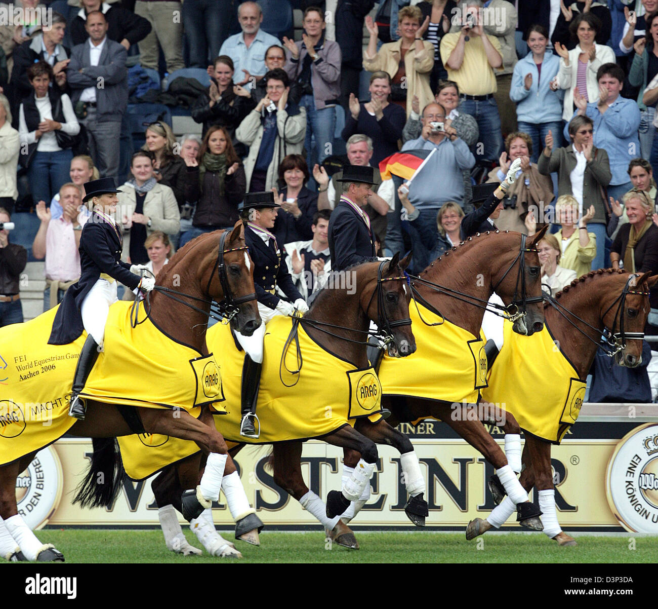 Deutscher Dressurreiter (L-R) Nadine Capellmann (auf Elvis), Isabell Werth (auf Satchmo), Hubertus Schmidt (auf Wansuela Suerte) und Heike Kemmer (auf Bonaparte) fahren während der ARAG Grand Prix bei den FEI World Equestrian Games Aachen 2006 in Aachen, Deutschland, Mittwoch, 23. August 2006 eine Ehrenrunde. Die deutsche Mannschaft gewann die Goldmedaille zum zehnten Mal. Die letzten deutschen Niederlage während einer Stockfoto Deutscher Dressurreiter (L-R) Nadine Capellmann (auf Elvis), Isabell Werth (auf Satchmo), Hubertus Schmidt (auf Wansuela Suerte) und Heike Kemmer (auf Bonaparte) fahren während der ARAG Grand Prix bei den FEI World Equestrian Games Aachen 2006 in Aachen, Deutschland, Mittwoch, 23. August 2006 eine Ehrenrunde. Die deutsche Mannschaft gewann die Goldmedaille zum zehnten Mal. Die letzten deutschen Niederlage während einer Stockfoto