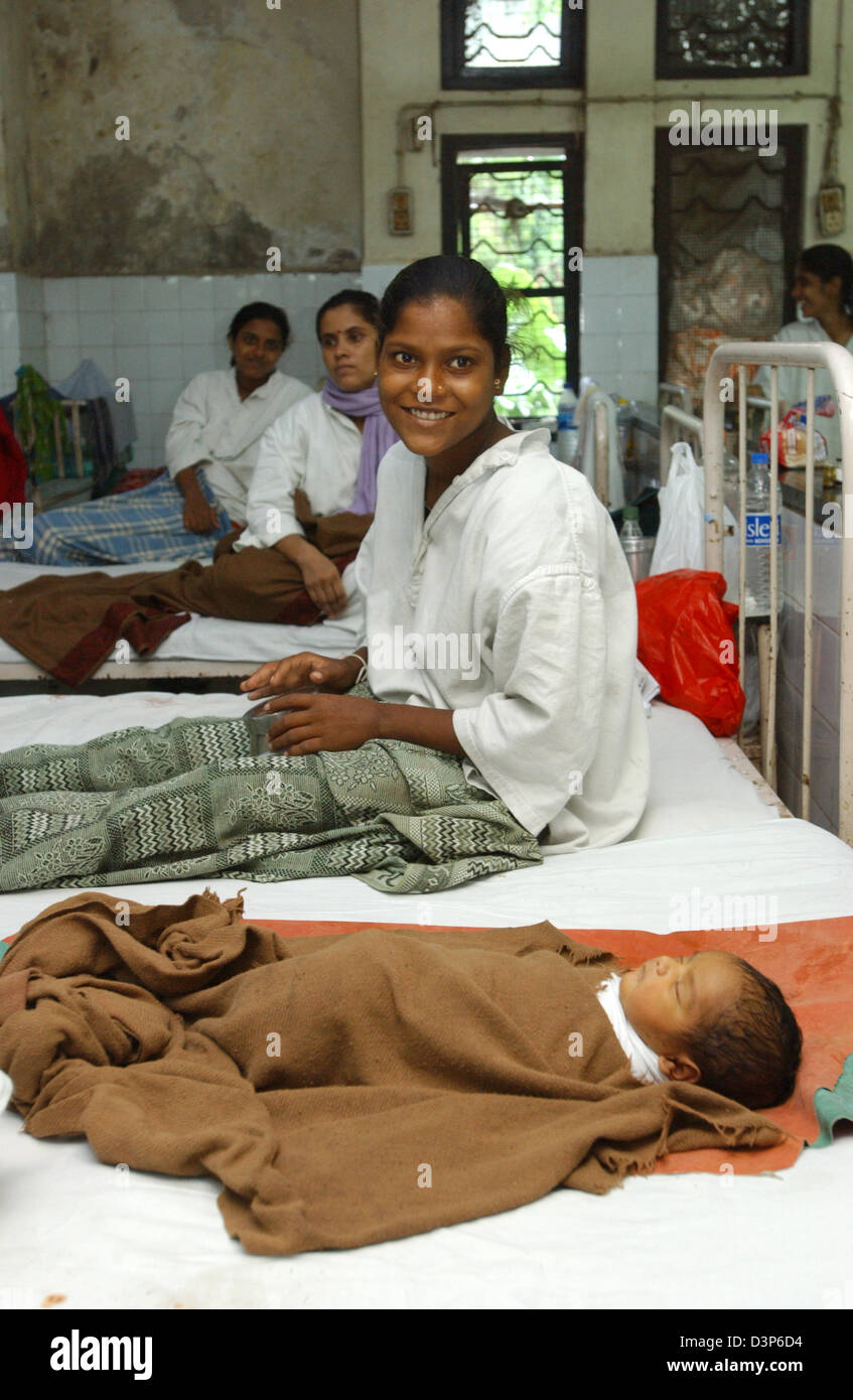(Dpa-Datei) - sitzt eine junge indische Mutter in ihrem Bett mit ihrem Neugeborenen Baby an ihrer Seite in einem Krankenhaus in Bombay, Indien, 4. Juli 2006. Foto: Wolfgang Langenstrassen Stockfoto