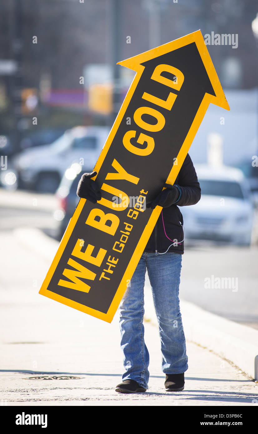 ARLINGTON, VIRGINIA, USA - Frau hält wir kaufen Gold Schild auf Bürgersteig, Kunden zu gewinnen. Stockfoto