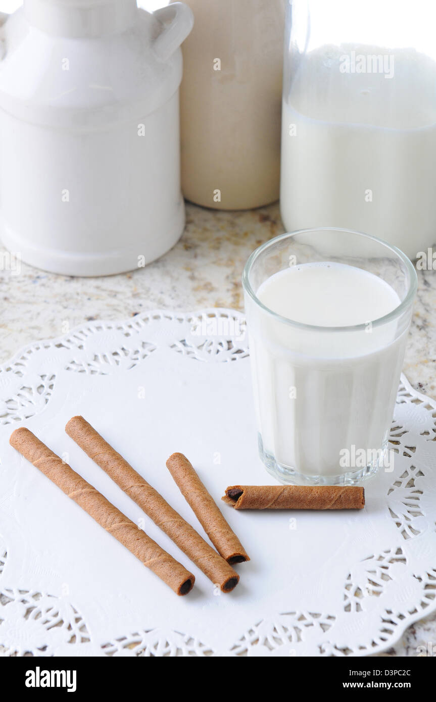 Vogelperspektive Blick auf ein Glas Milch und Wafer Cookies auf einem Küchentisch. Hochformat. Stockfoto