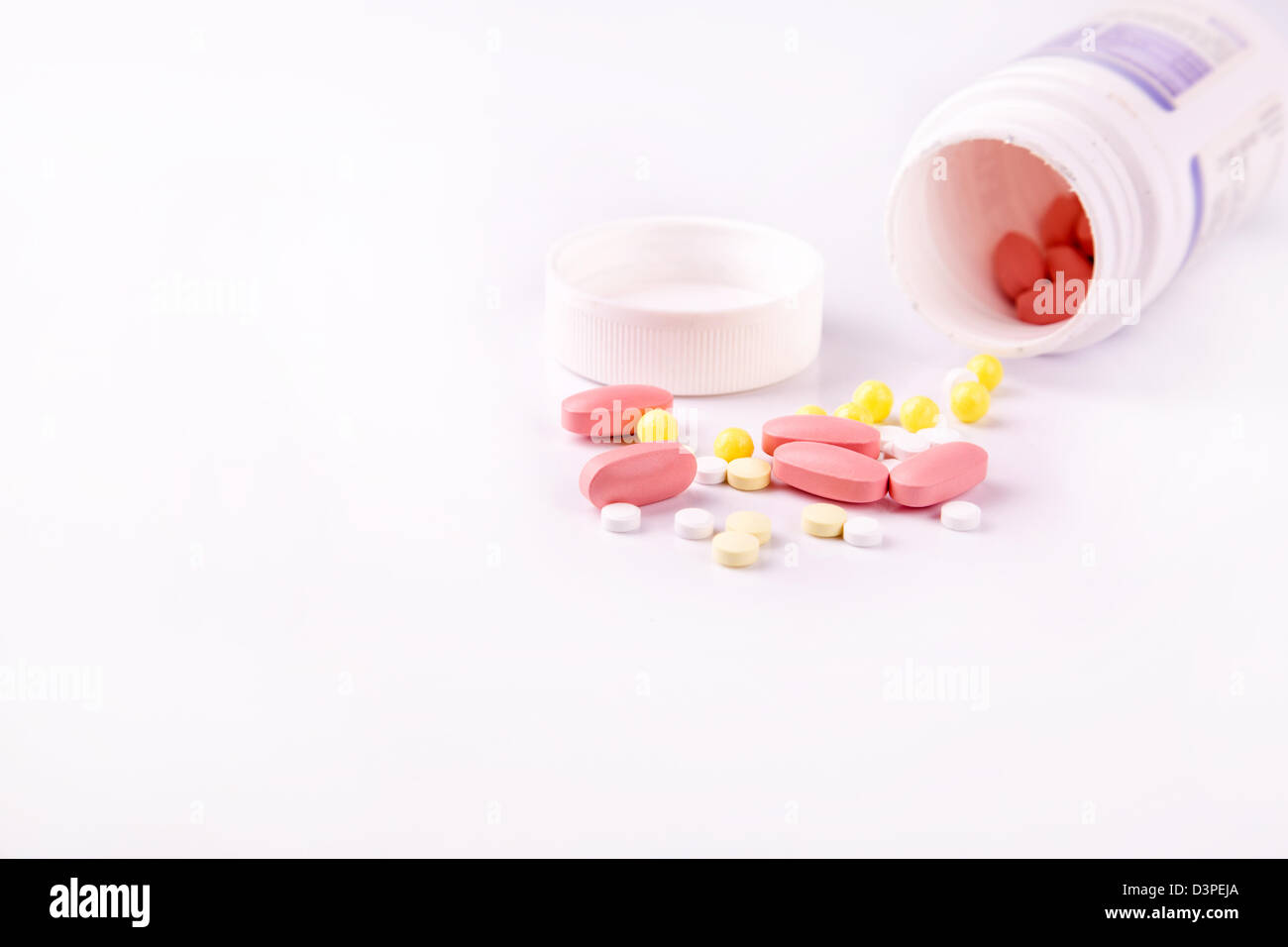 Medizin und Pillen der weißen Flasche ausgießen verstreut Stockfoto