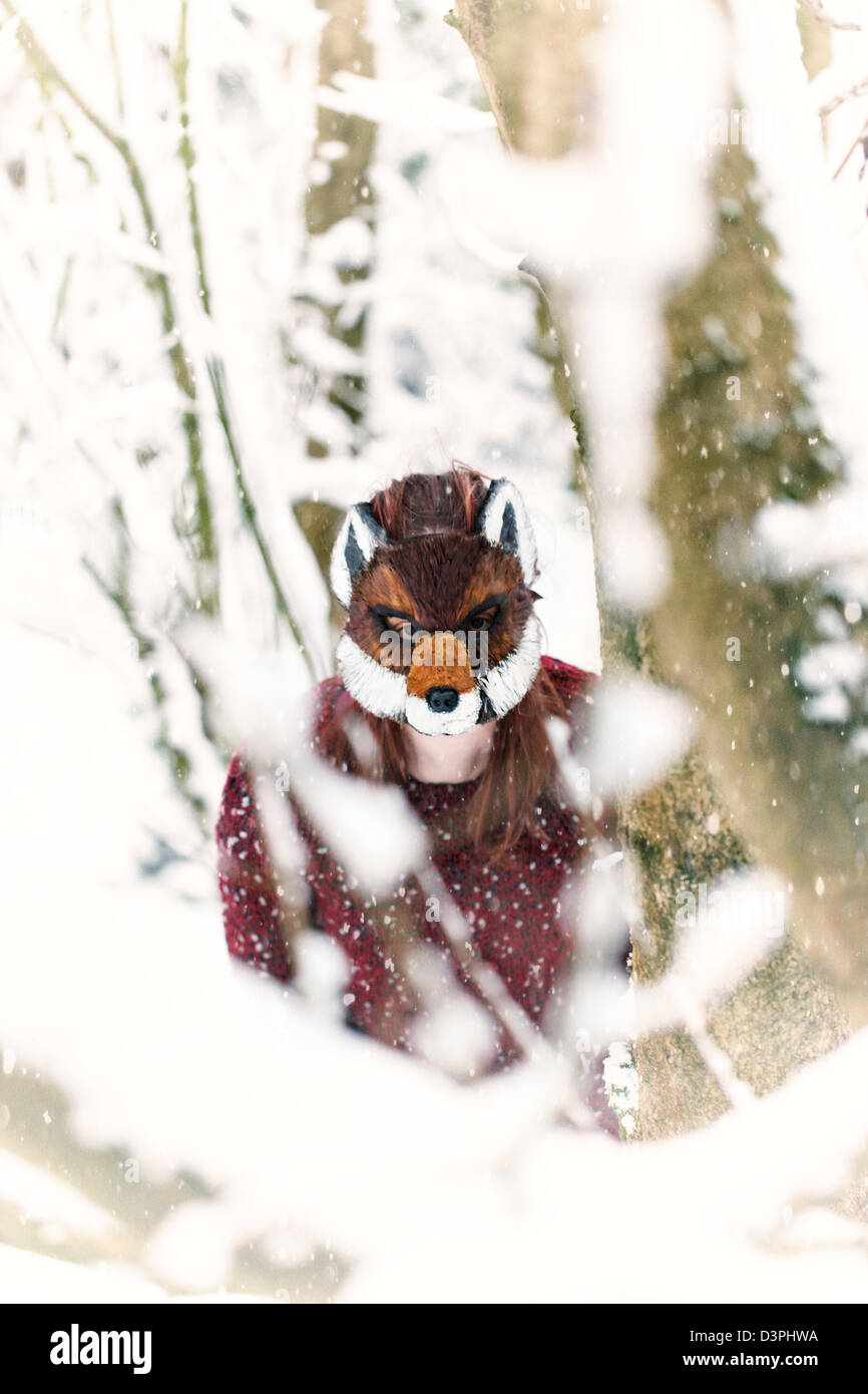 Frau trägt eine Maskierung Fuchs im Schnee Stockfoto