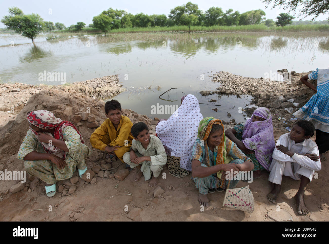 Muzaffergar, Pakistan, sitzen Kinder am Rande über überfluteten Felder Stockfoto