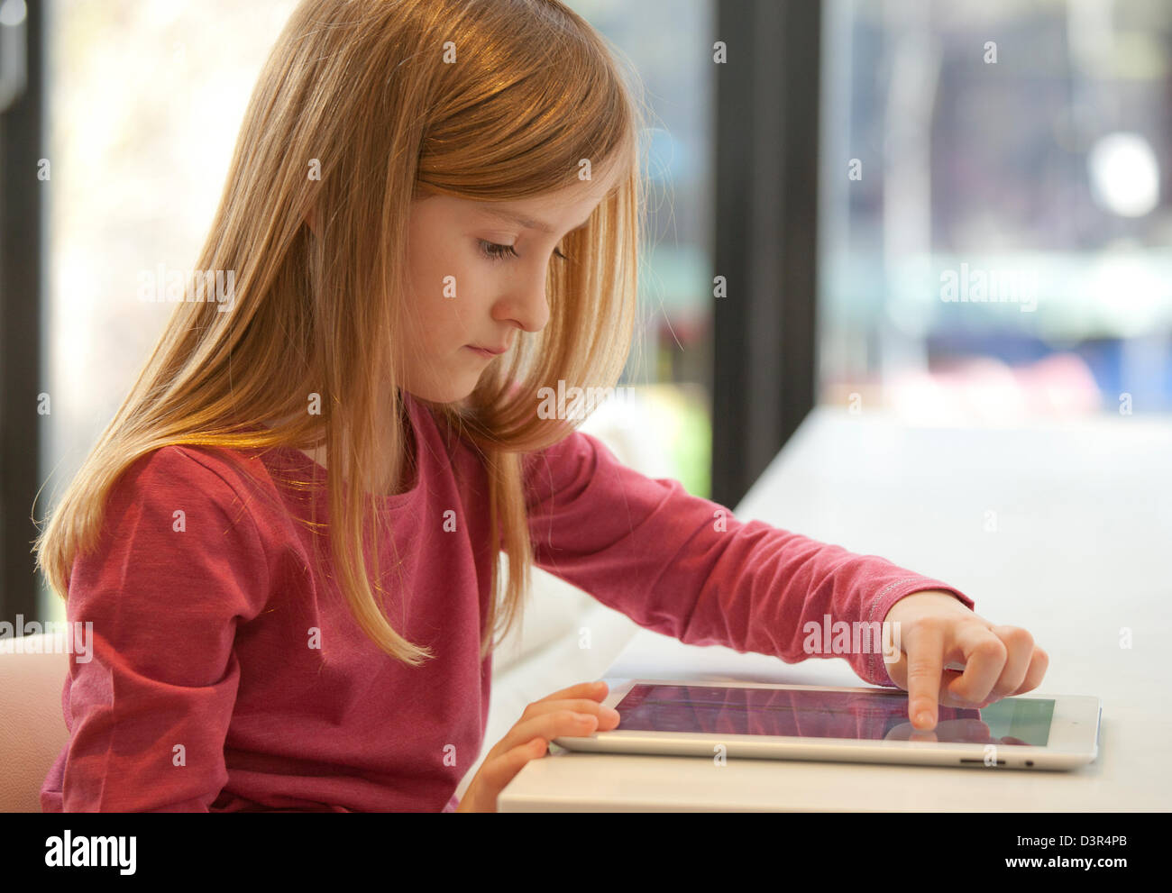 Junge Mädchen spielen auf einem Apple iPad Tablet-computer Stockfoto