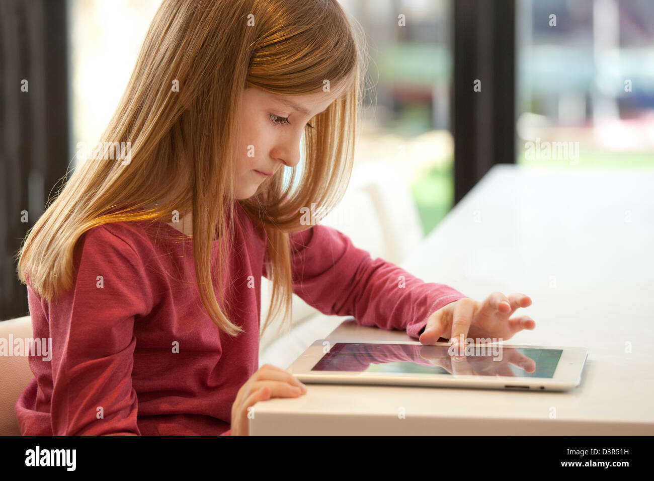 Junge Mädchen spielen auf einem Apple iPad Tablet-computer Stockfoto