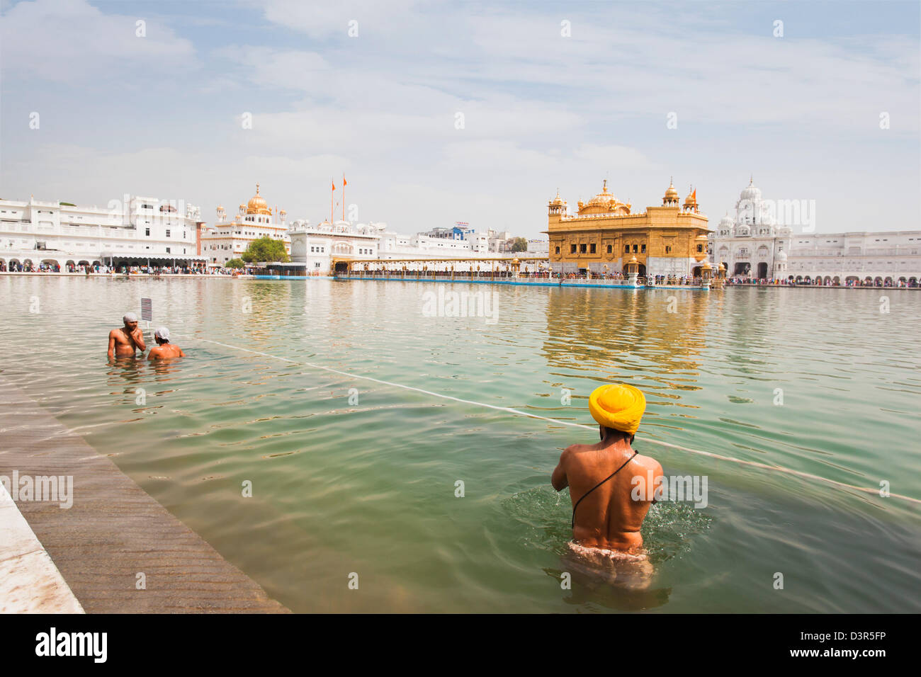 Sikh-Pilger Baden im Nektar Teich am goldenen Tempel in Amritsar, Punjab, Indien Stockfoto