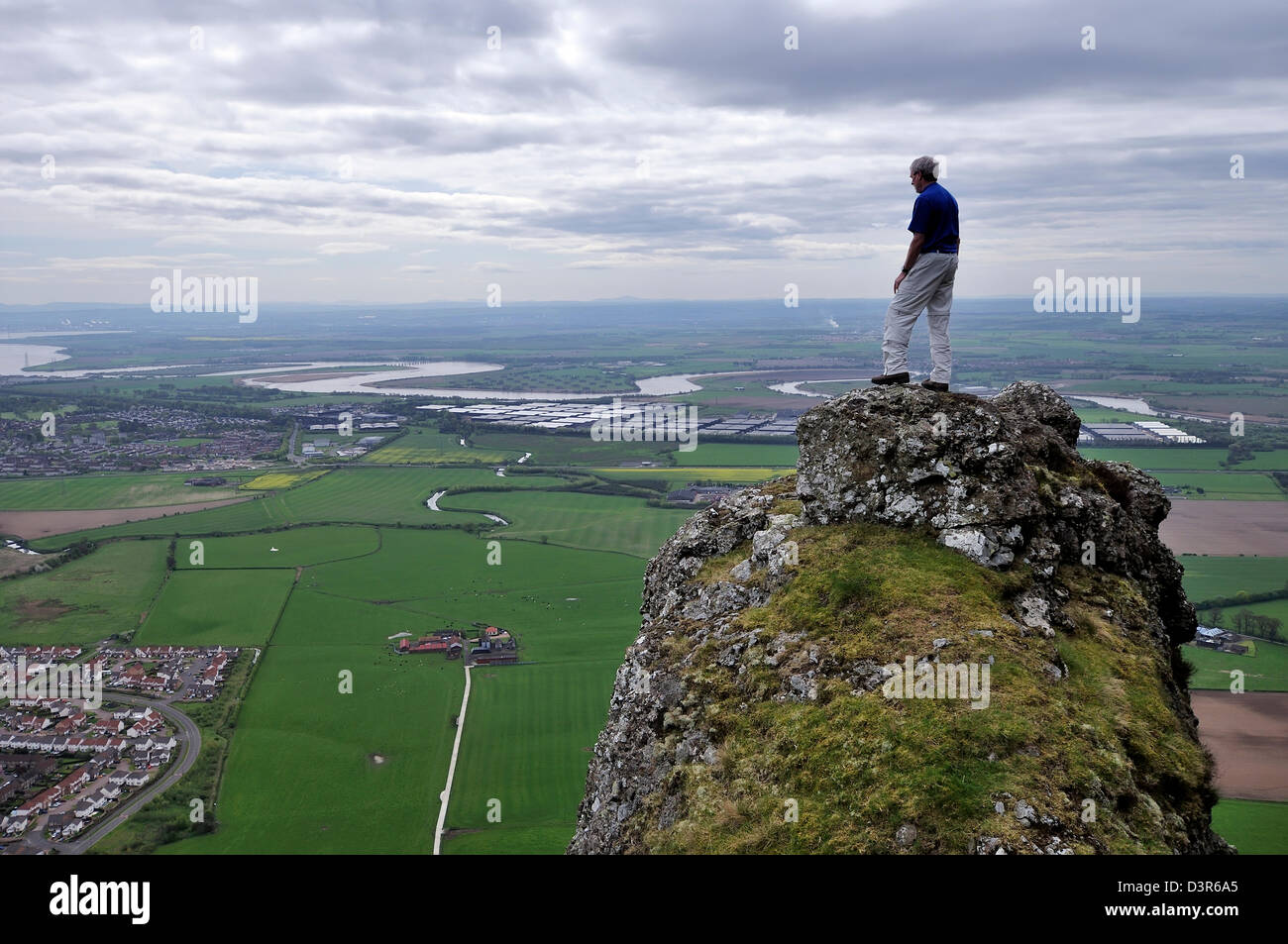 Ein Hillwalker steht auf einem Fels-Gipfel und blickt auf den Fluss Forth Stockfoto