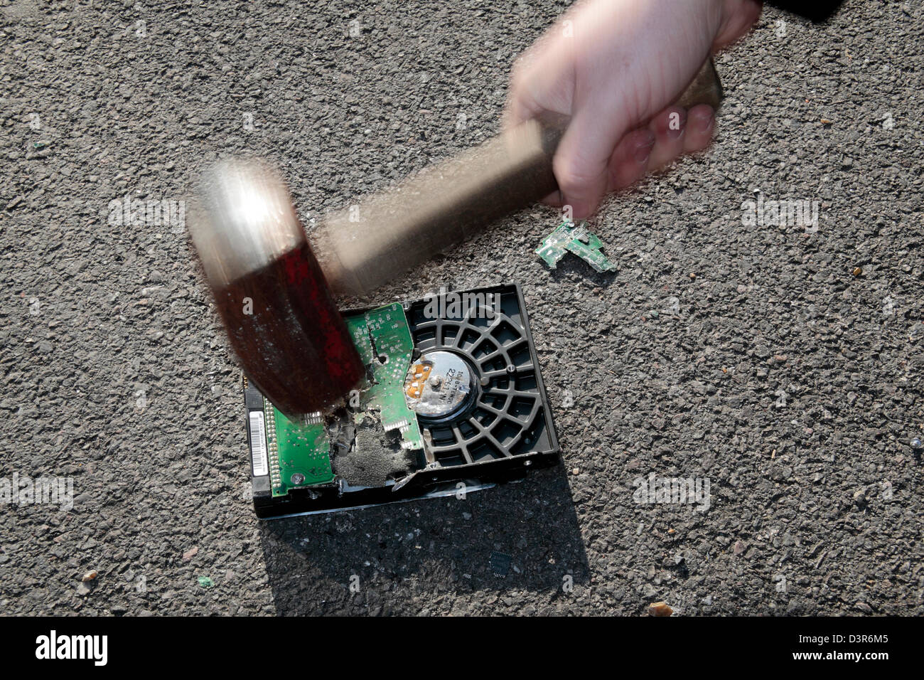 Ein Hammer auf einer PC-Festplatte in einem Versuch zu verhindern, dass Daten gestohlen werden. Stockfoto