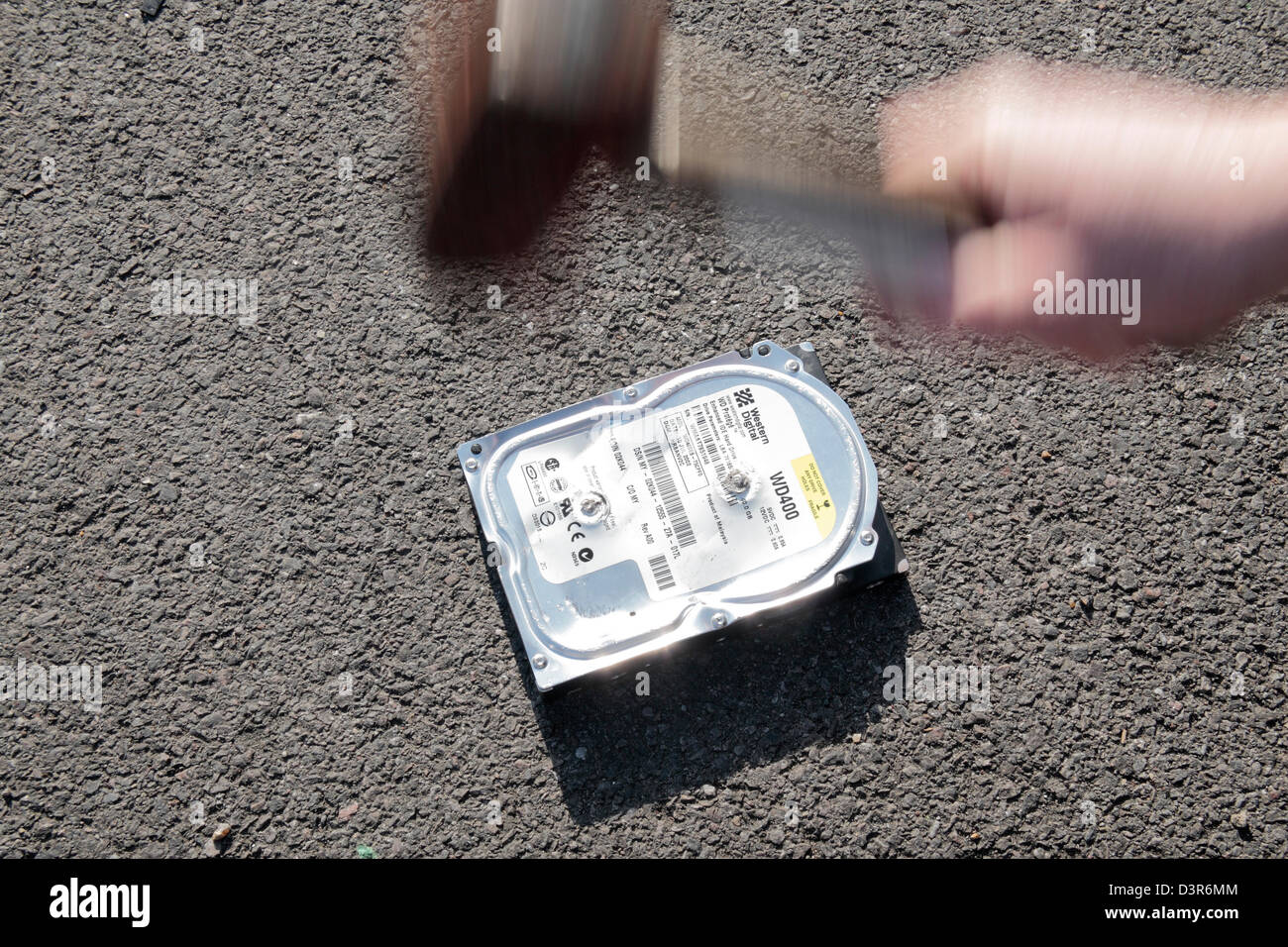 Ein Hammer auf einer PC-Festplatte in einem Versuch zu verhindern, dass Daten gestohlen werden. Stockfoto