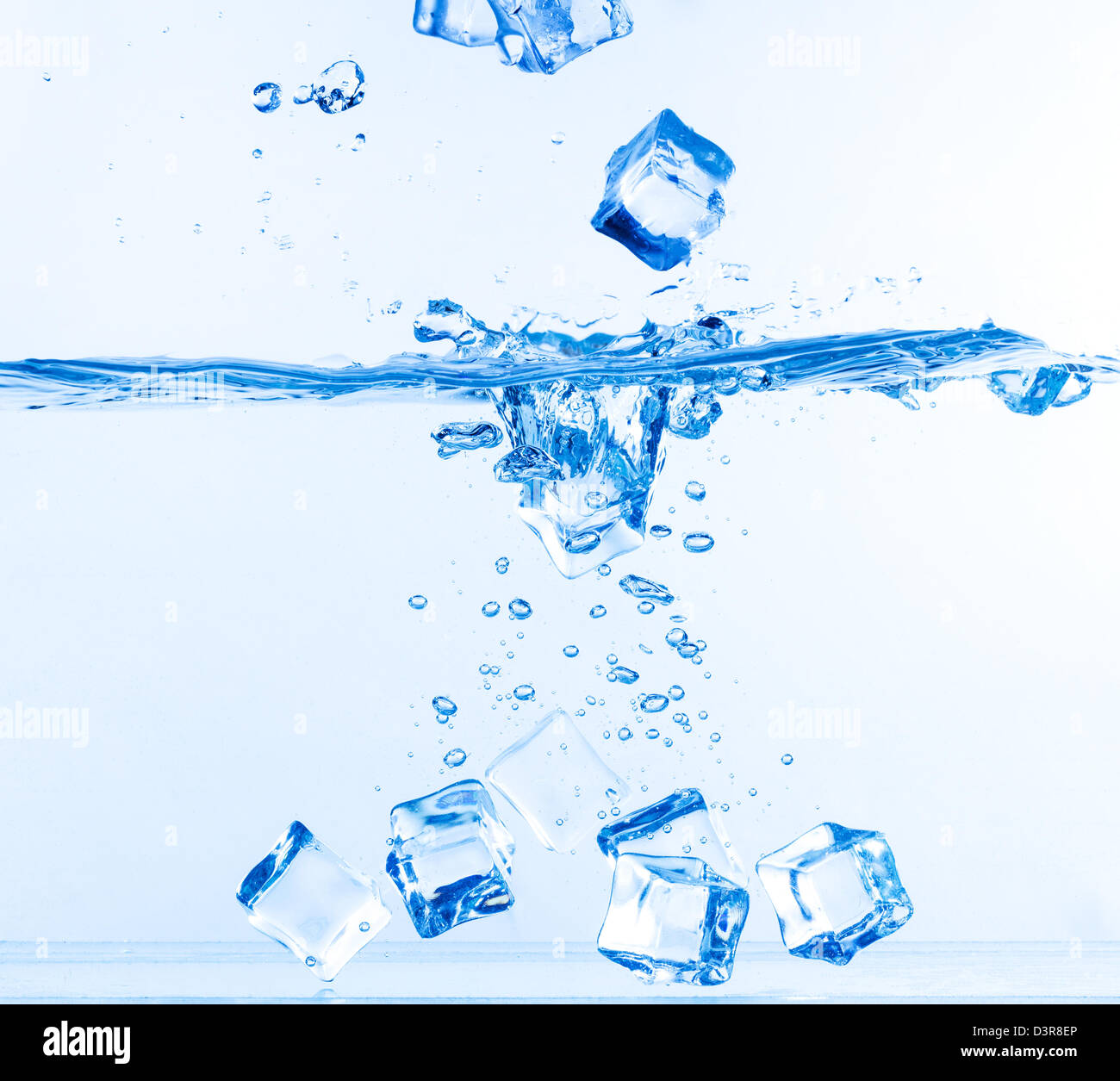 Ice Cubes fiel ins Wasser mit Spritzen auf weiß Stockfoto