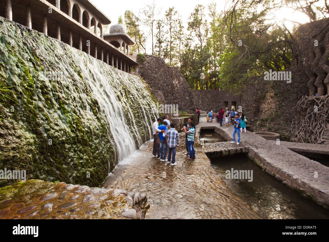 Menschen genießen in einem Wasserfall am Rock Garten von Nek Chand Saini, Steingarten von Chandigarh, Indien Stockfoto