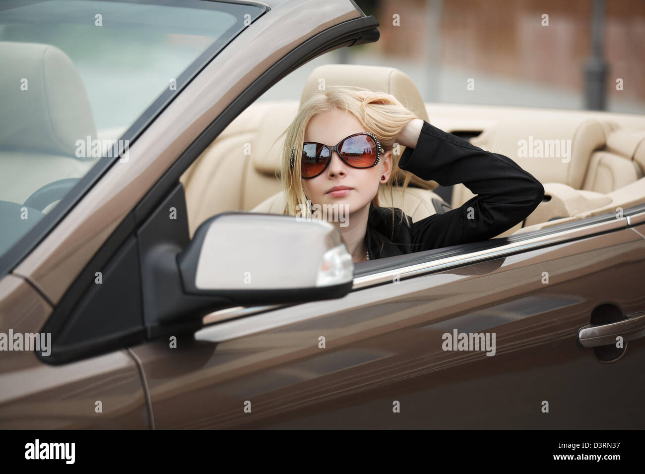 Junge Frau in einem Cabrio Stockfoto
