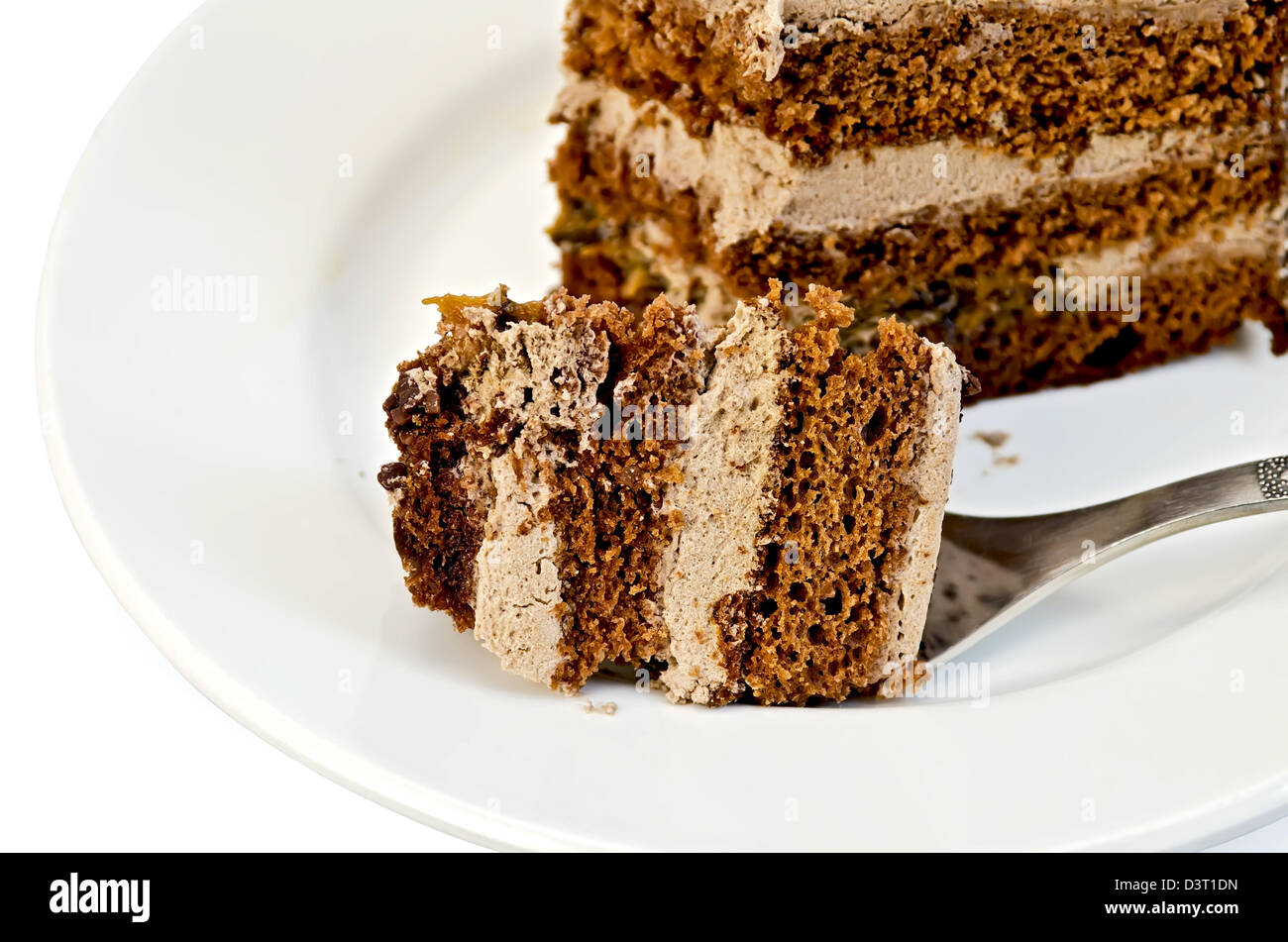 Brechen Sie ein Stück Kuchen auf eine Gabel mit einer weißen Platte auf weißem Hintergrund Stockfoto